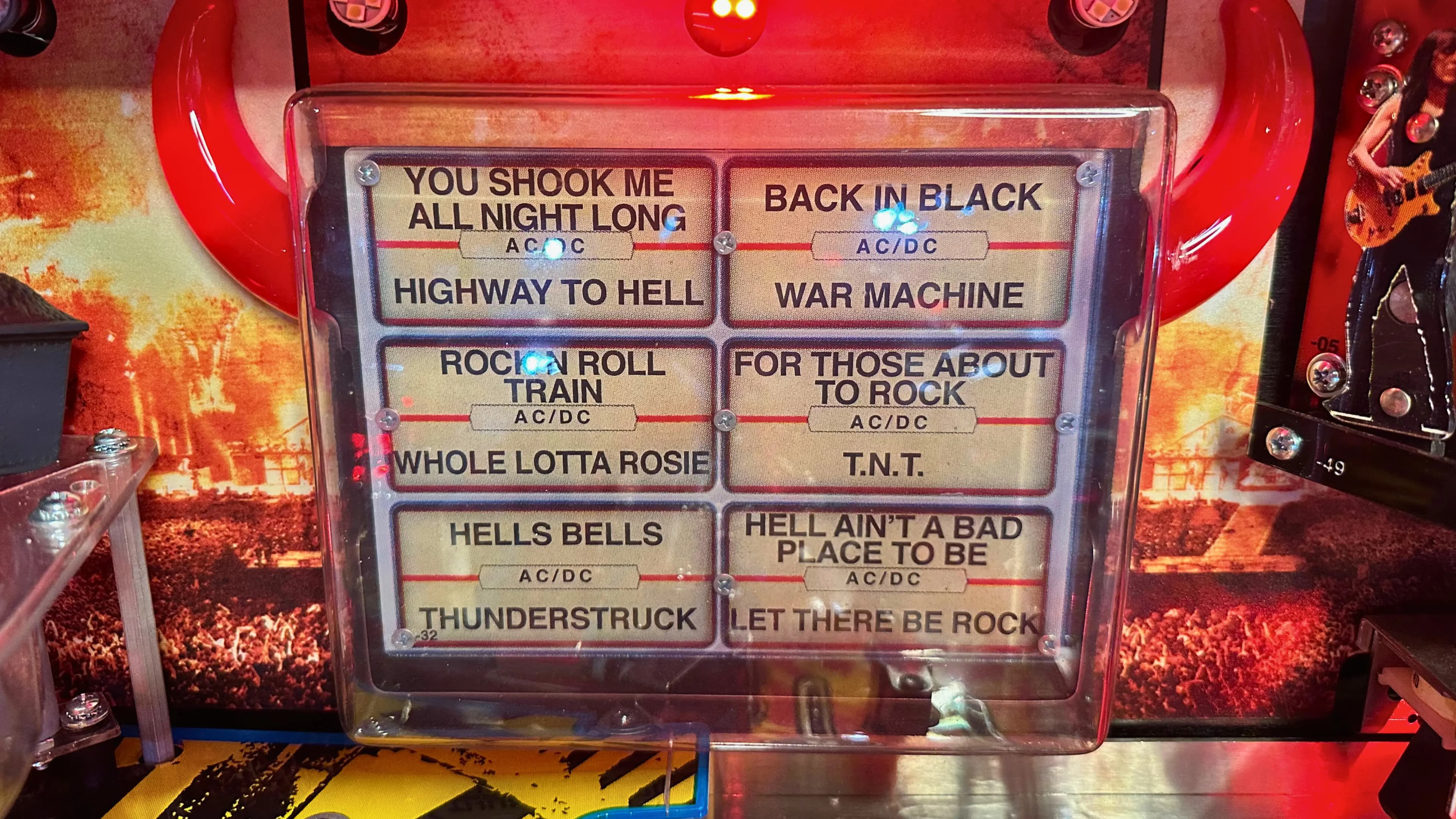 AC/DC song list display with rock concert background and glowing lights