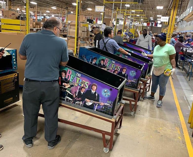 Beatles pinball machines being assembled in a busy factory production line