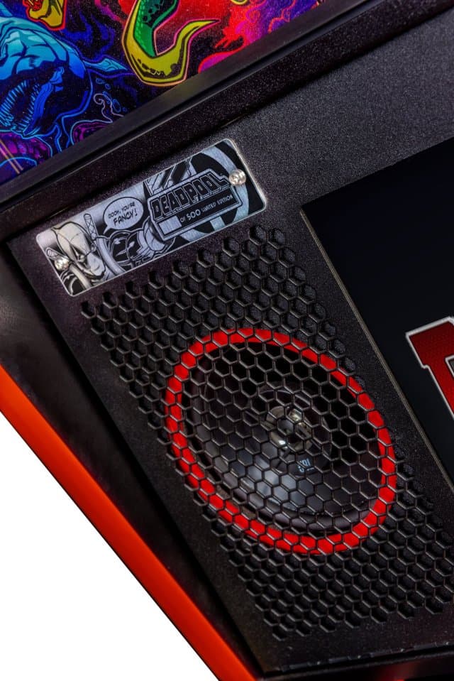 Computer speaker with red circular grille and comic book style sticker