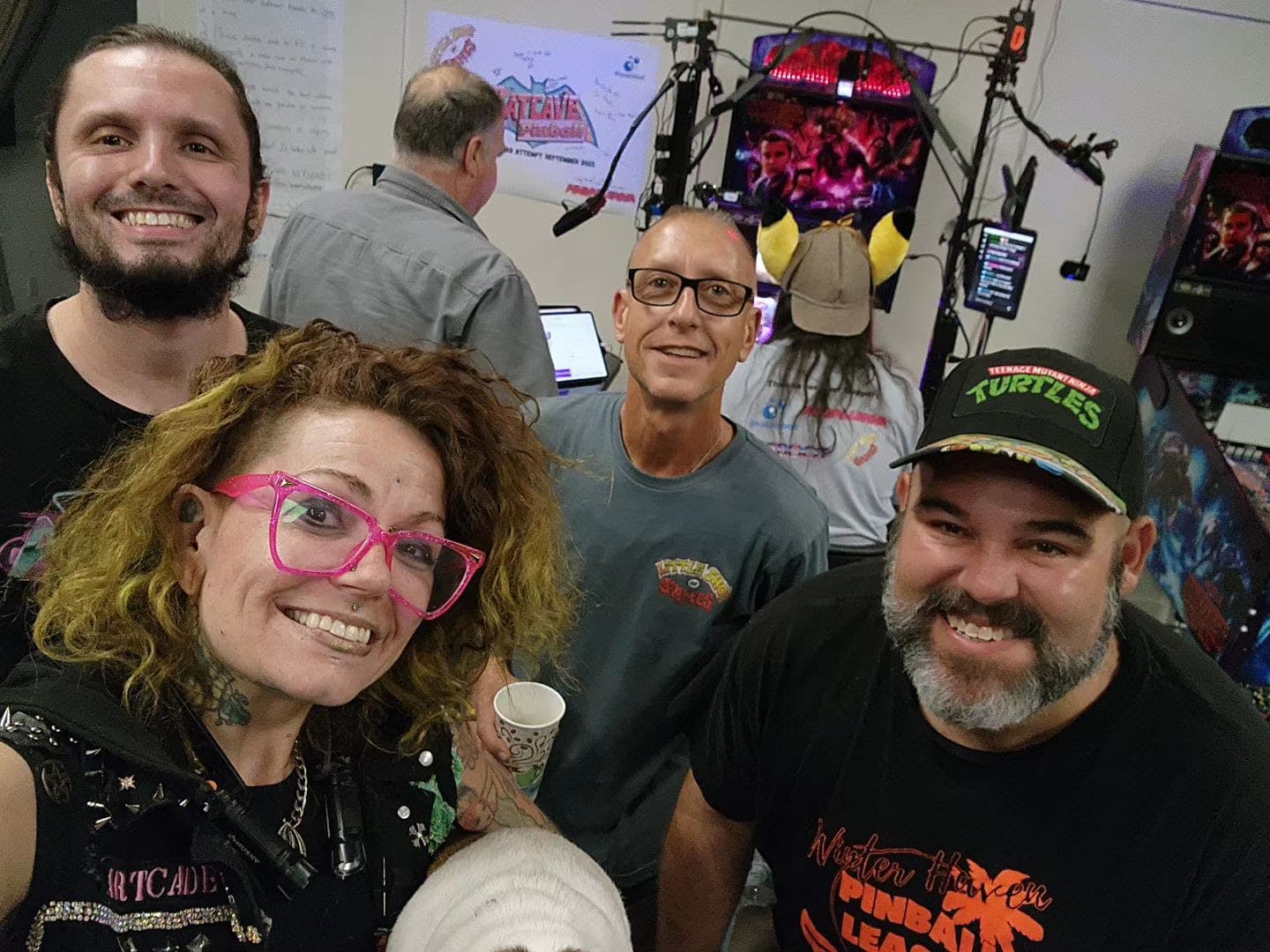 Smiling team in gaming studio with colorful tech equipment