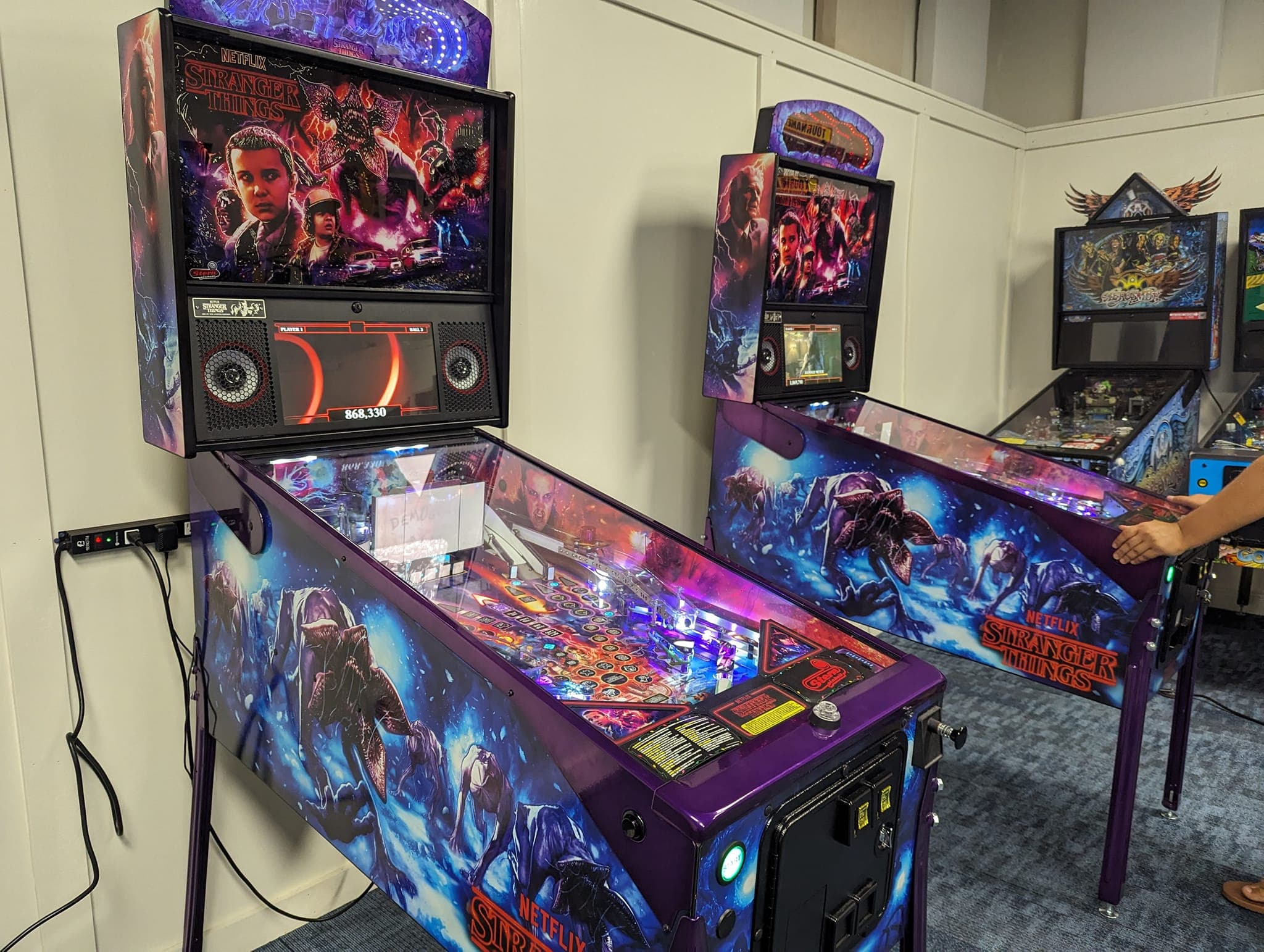 Stranger Things pinball machine with colorful artwork and illuminated playfield