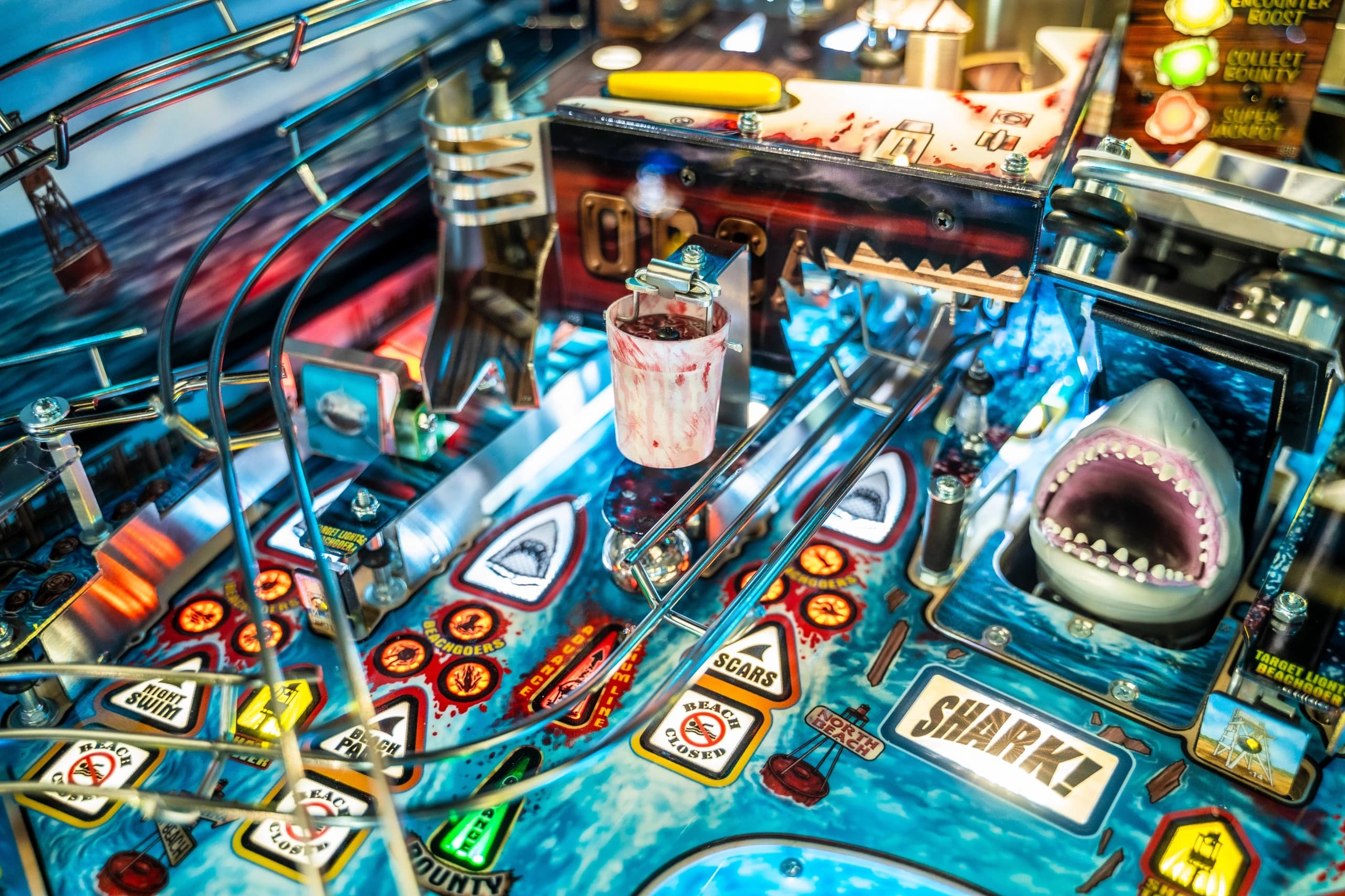 Detailed close-up of a shark-themed pinball machine with colorful elements