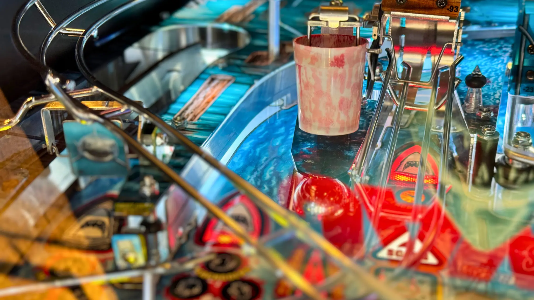 Vintage pinball machine interior with colorful mechanical components and red accents