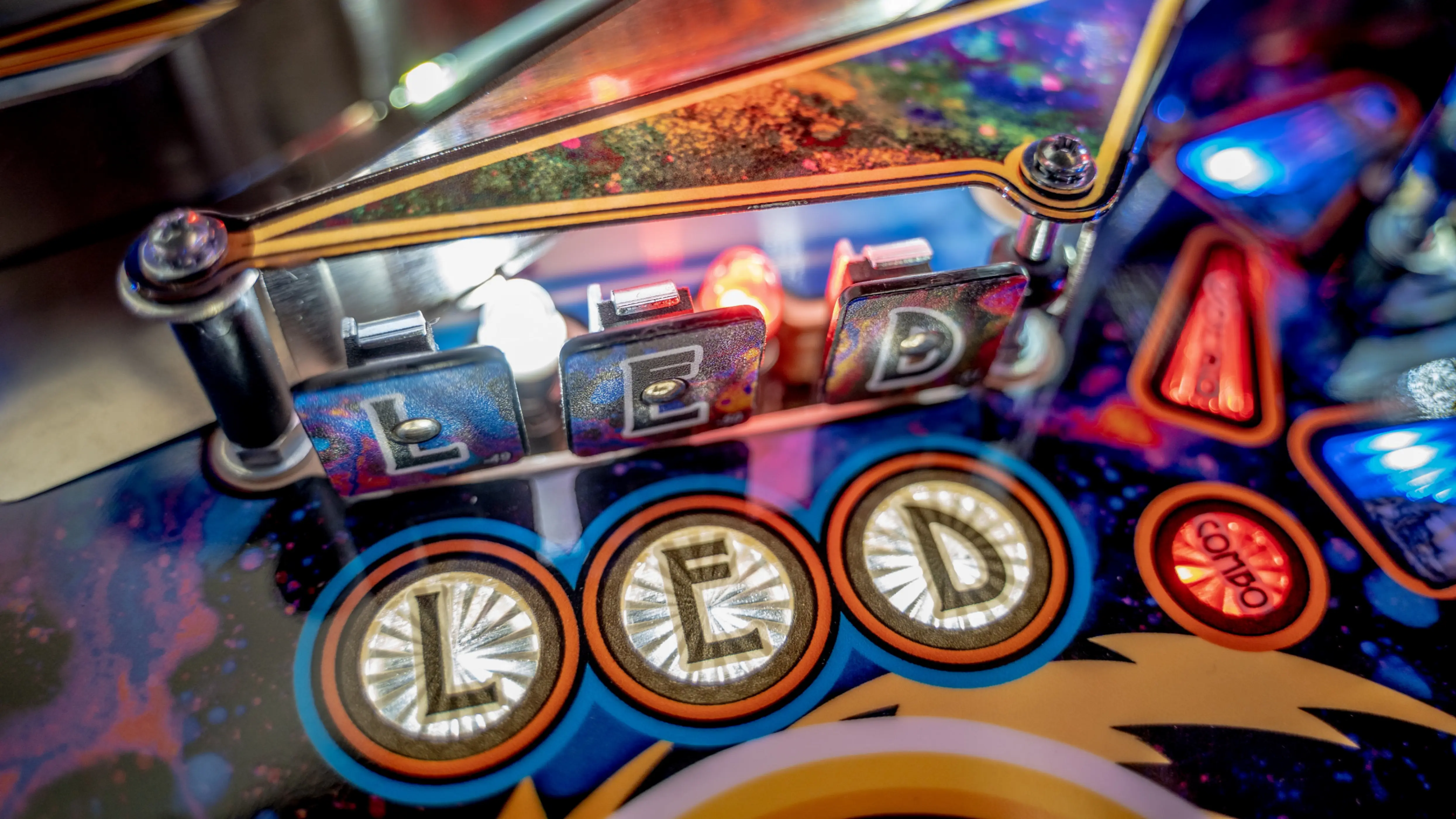 Colorful pinball machine dashboard with illuminated letters and buttons