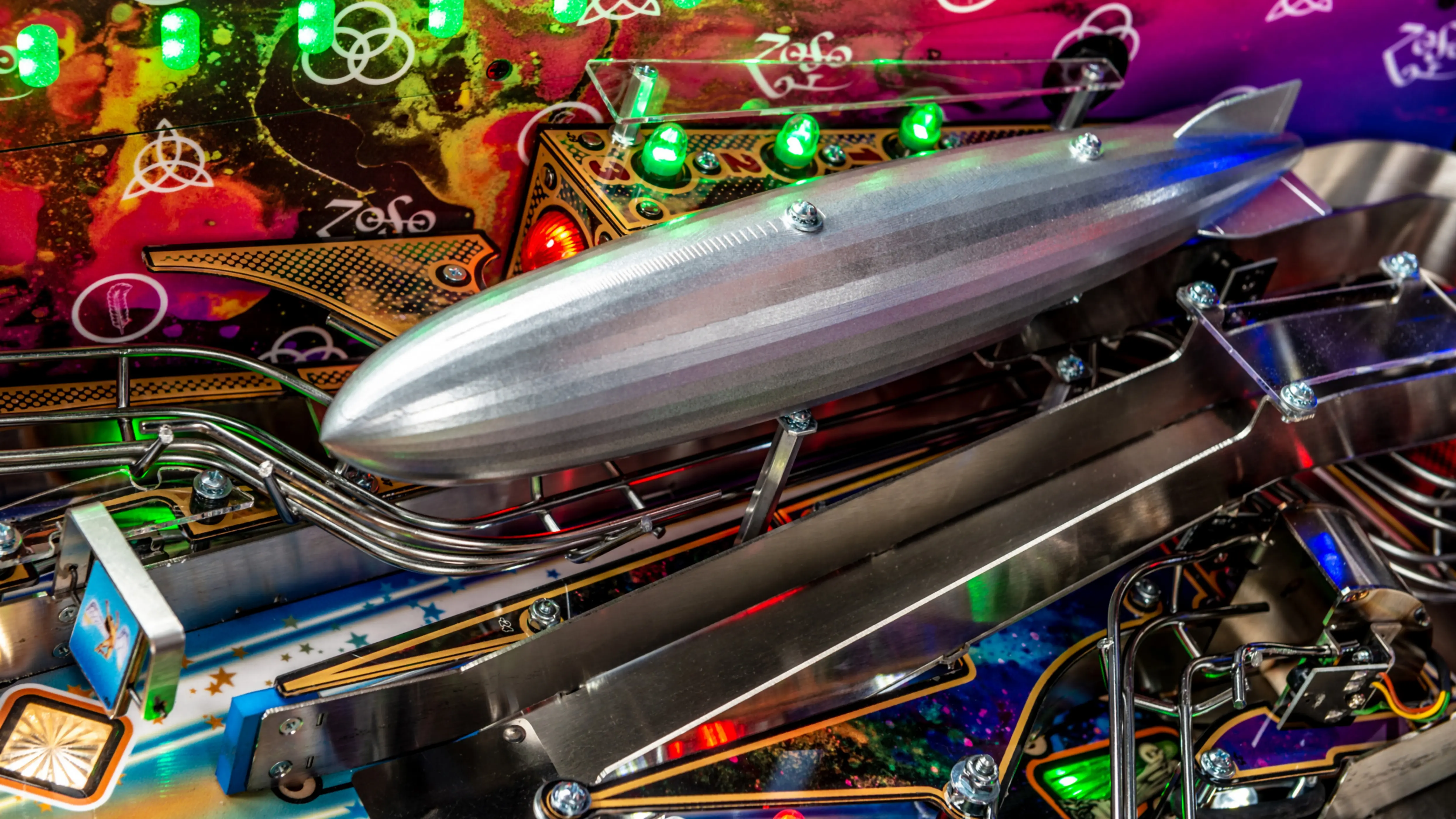 Silver zeppelin model on colorful pinball machine with vibrant lights