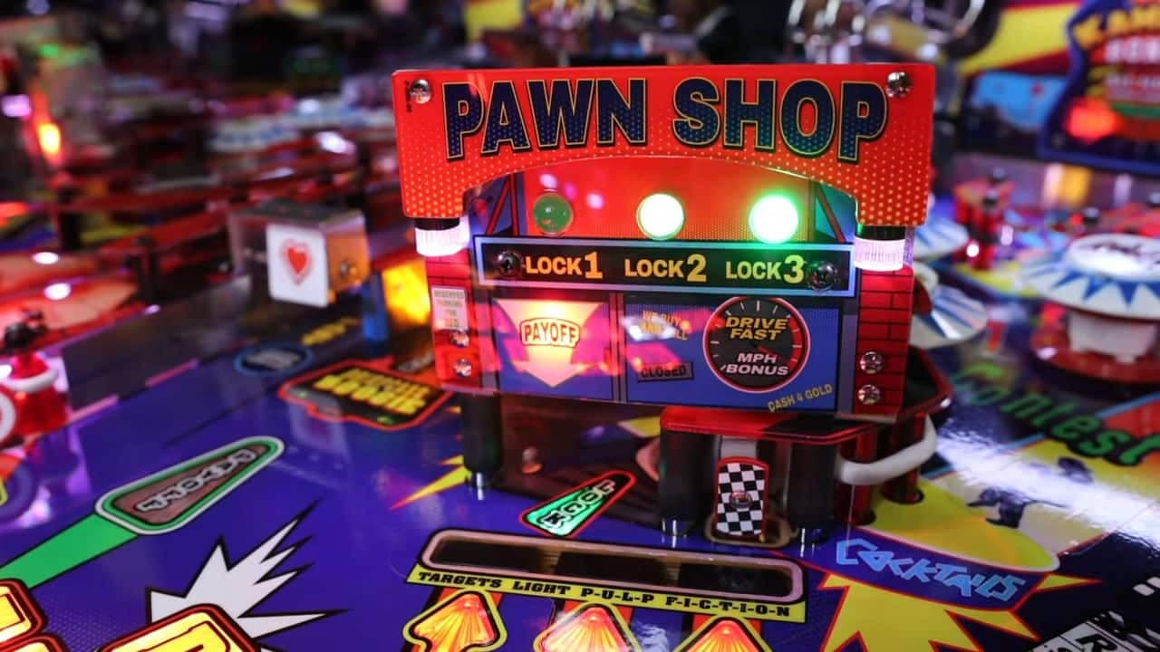 Colorful pinball machine with illuminated Pawn Shop sign and game controls