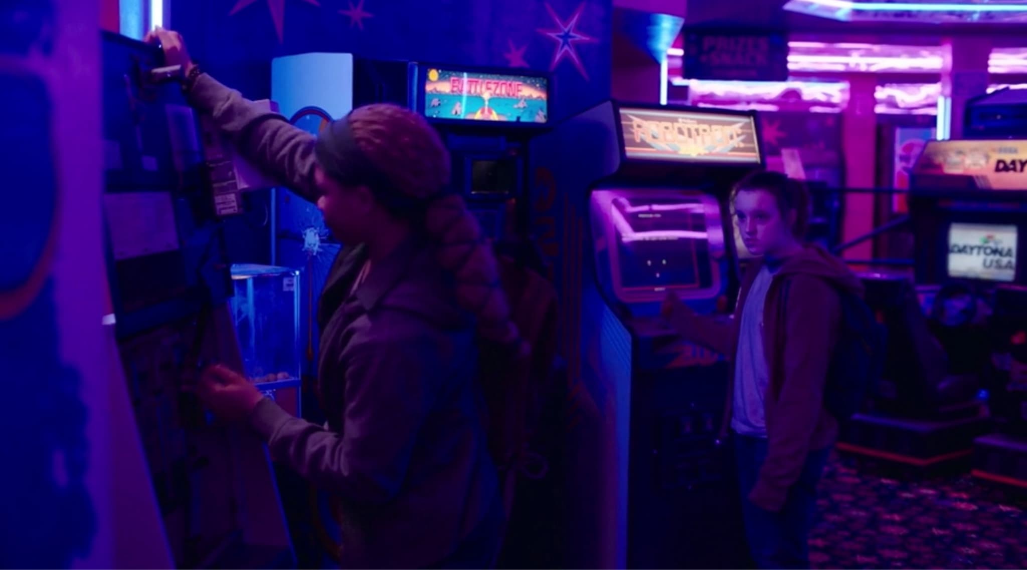 Arcade with neon lights, people playing video games in blue-purple atmosphere