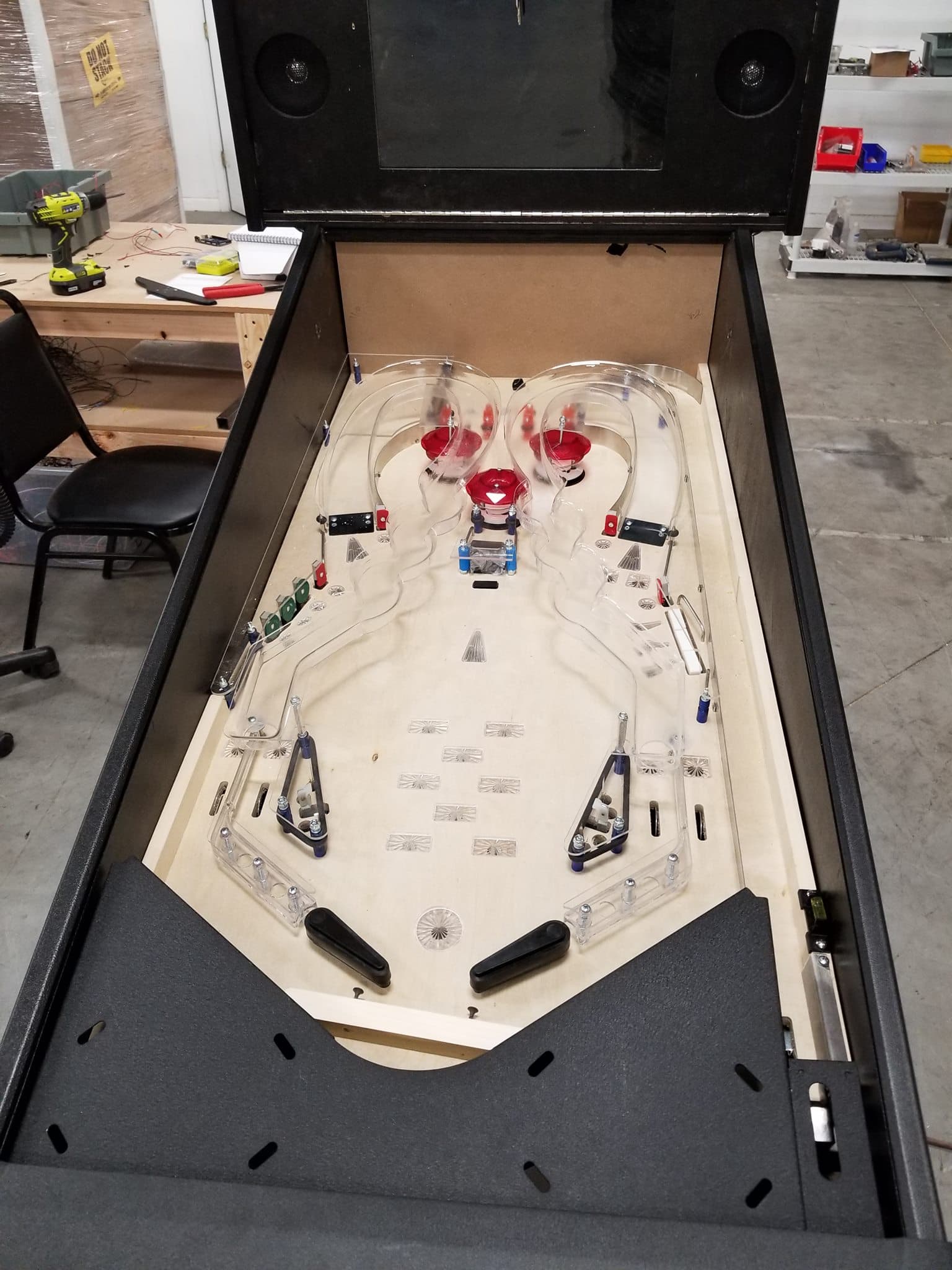 Custom handmade pinball machine with clear playfield in workshop