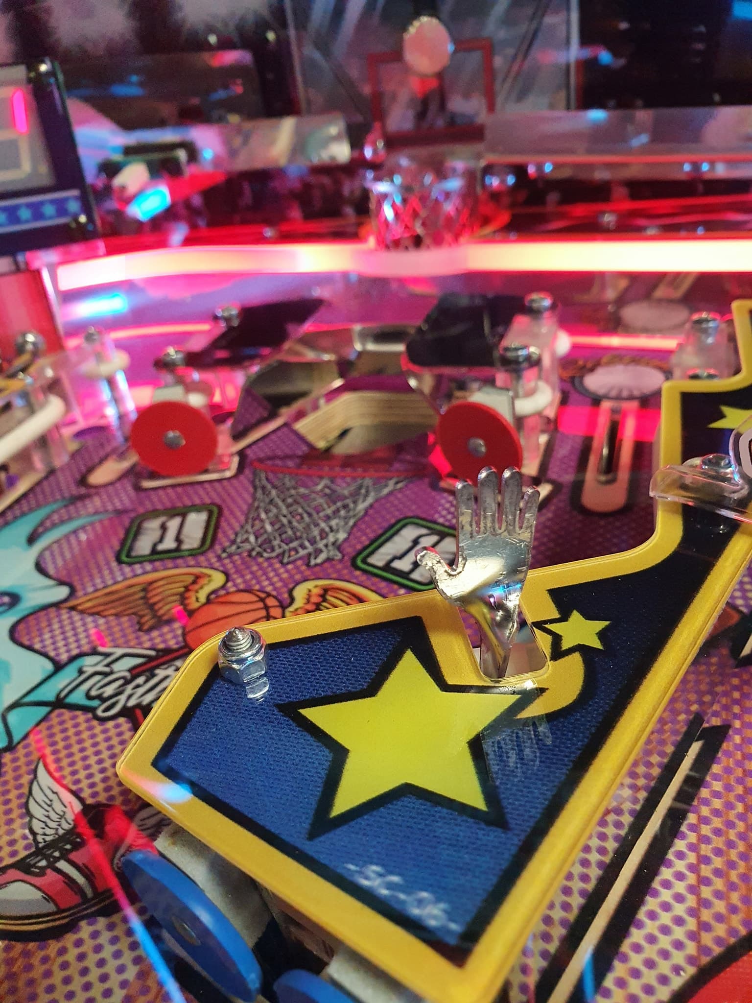 Colorful pinball machine with silver hand and star details