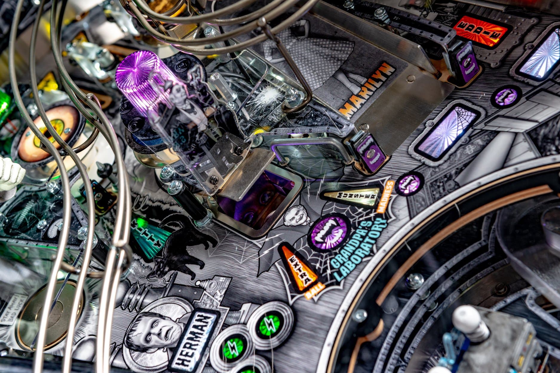 Intricate pinball machine with complex electronics, purple lights, and graphic details