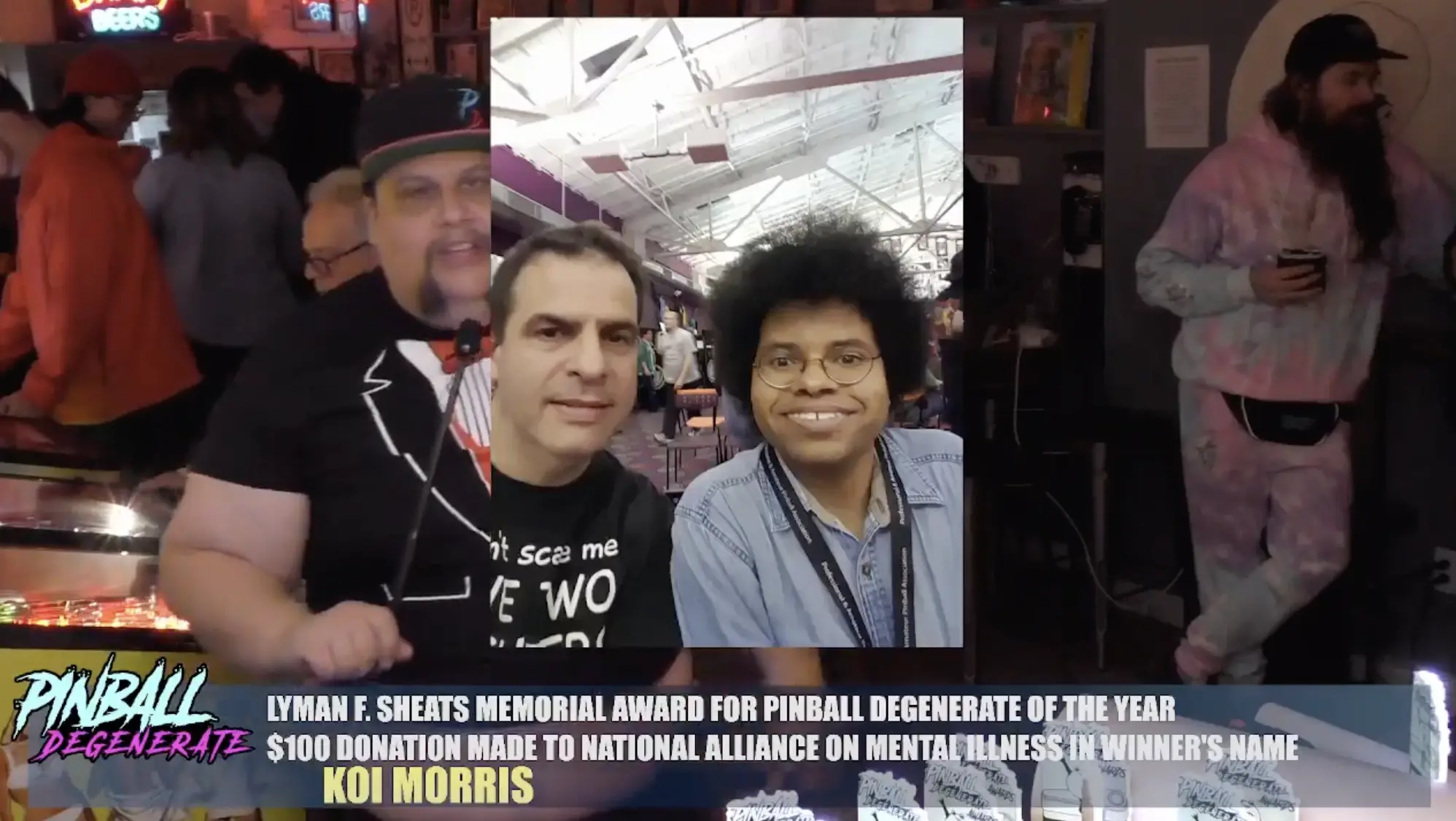 Two smiling people at pinball event with award banner