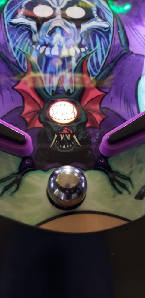 Demonic skull and bat-like creature with glowing eyes and reflective orb