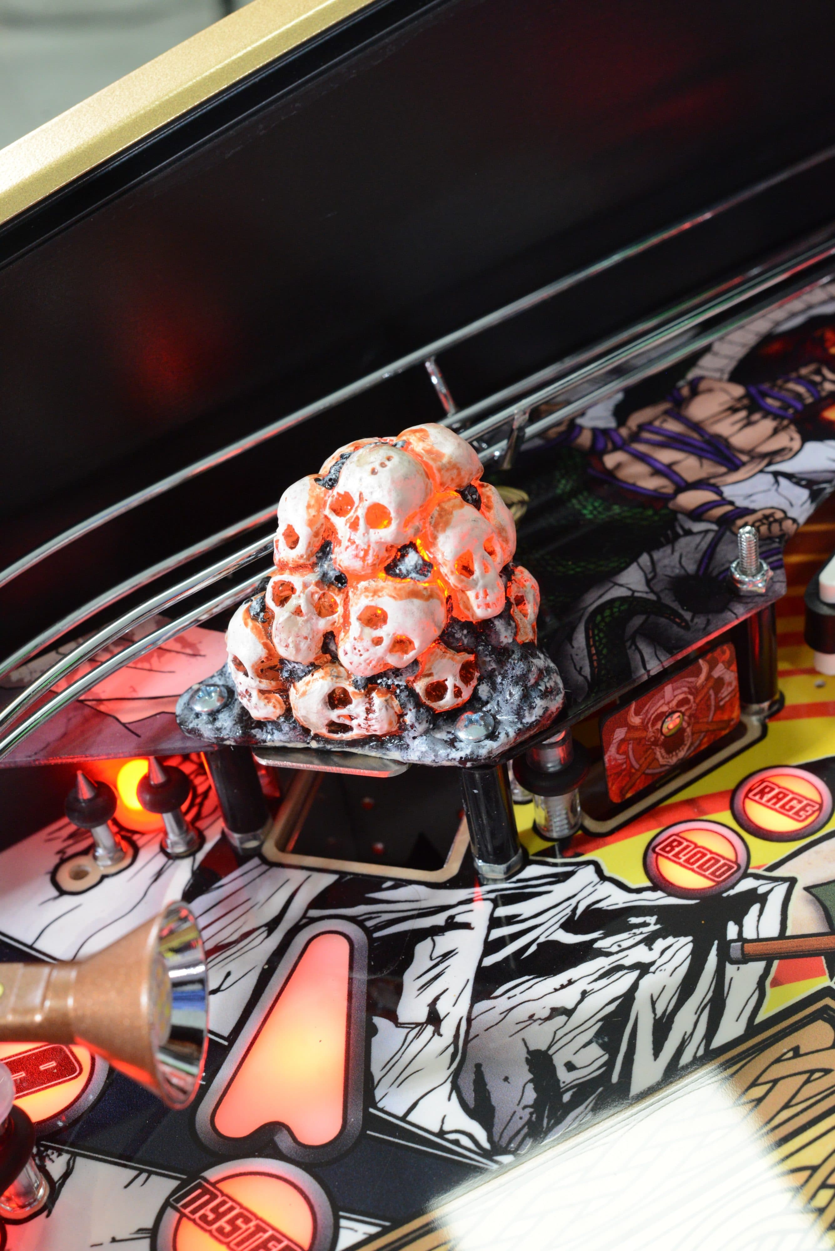 Pile of glowing skulls on a colorful pinball machine backboard