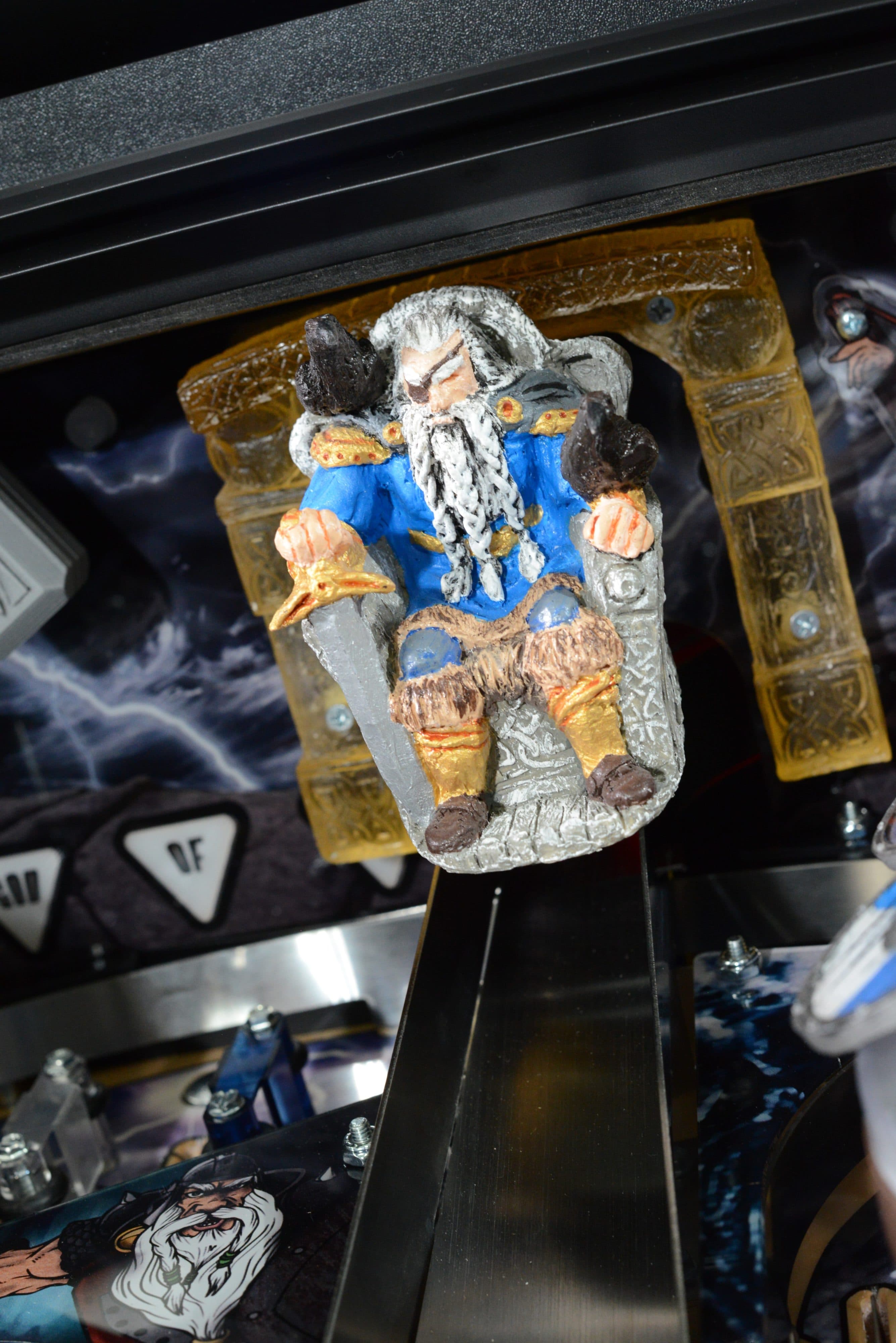 Miniature dwarf figurine with blue coat seated in ornate golden frame