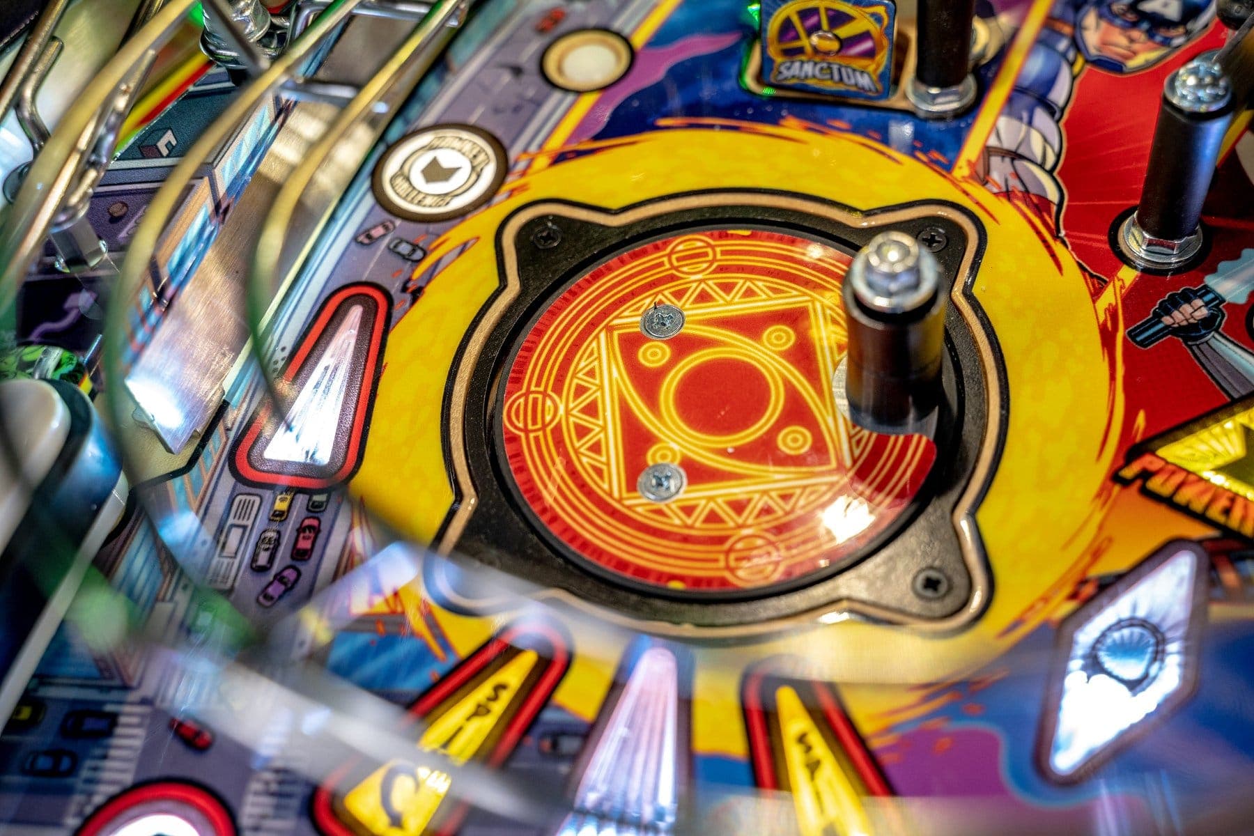 Colorful pinball machine detail with ornate yellow and red design element
