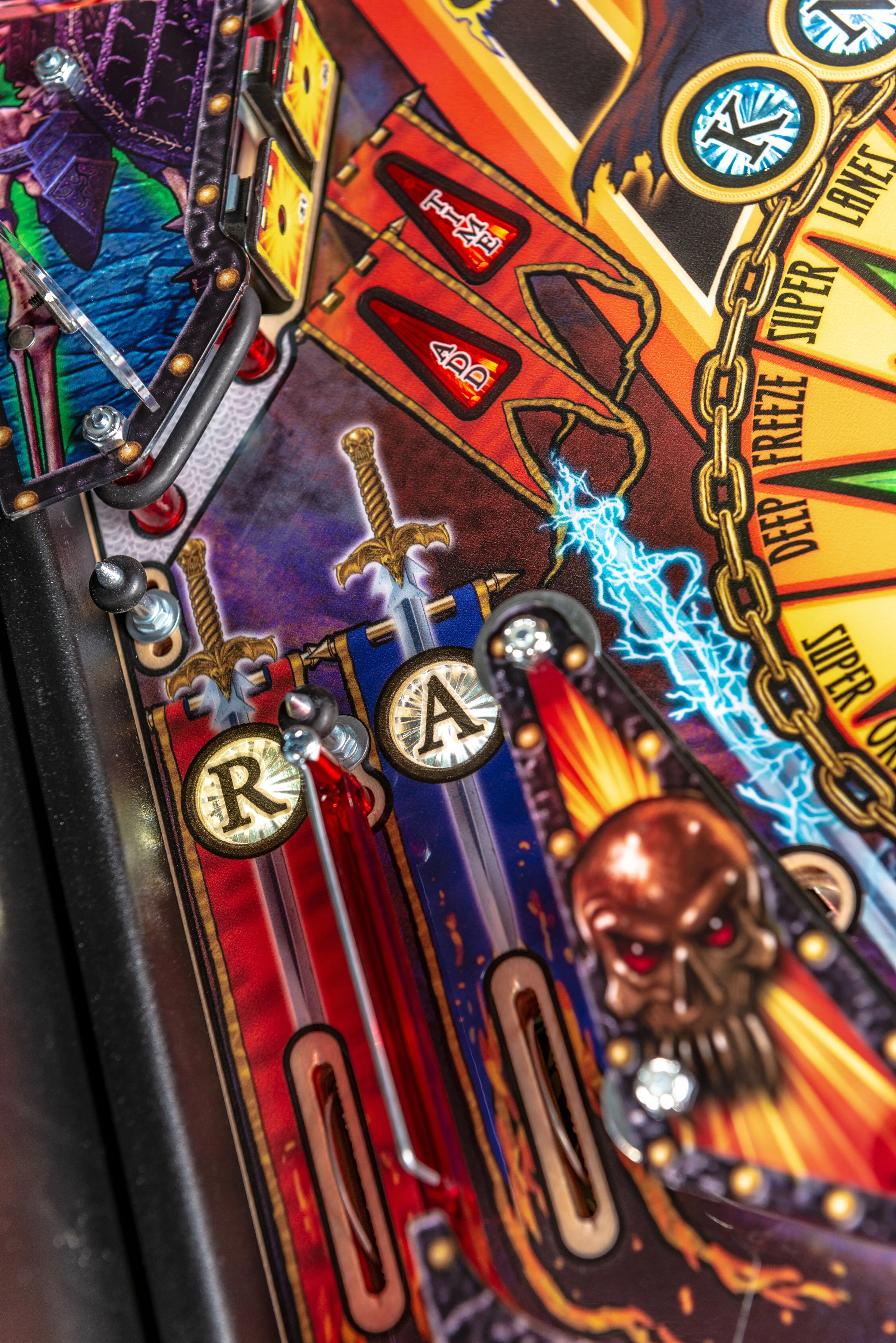 Colorful pinball machine with letters, sword, and lightning details
