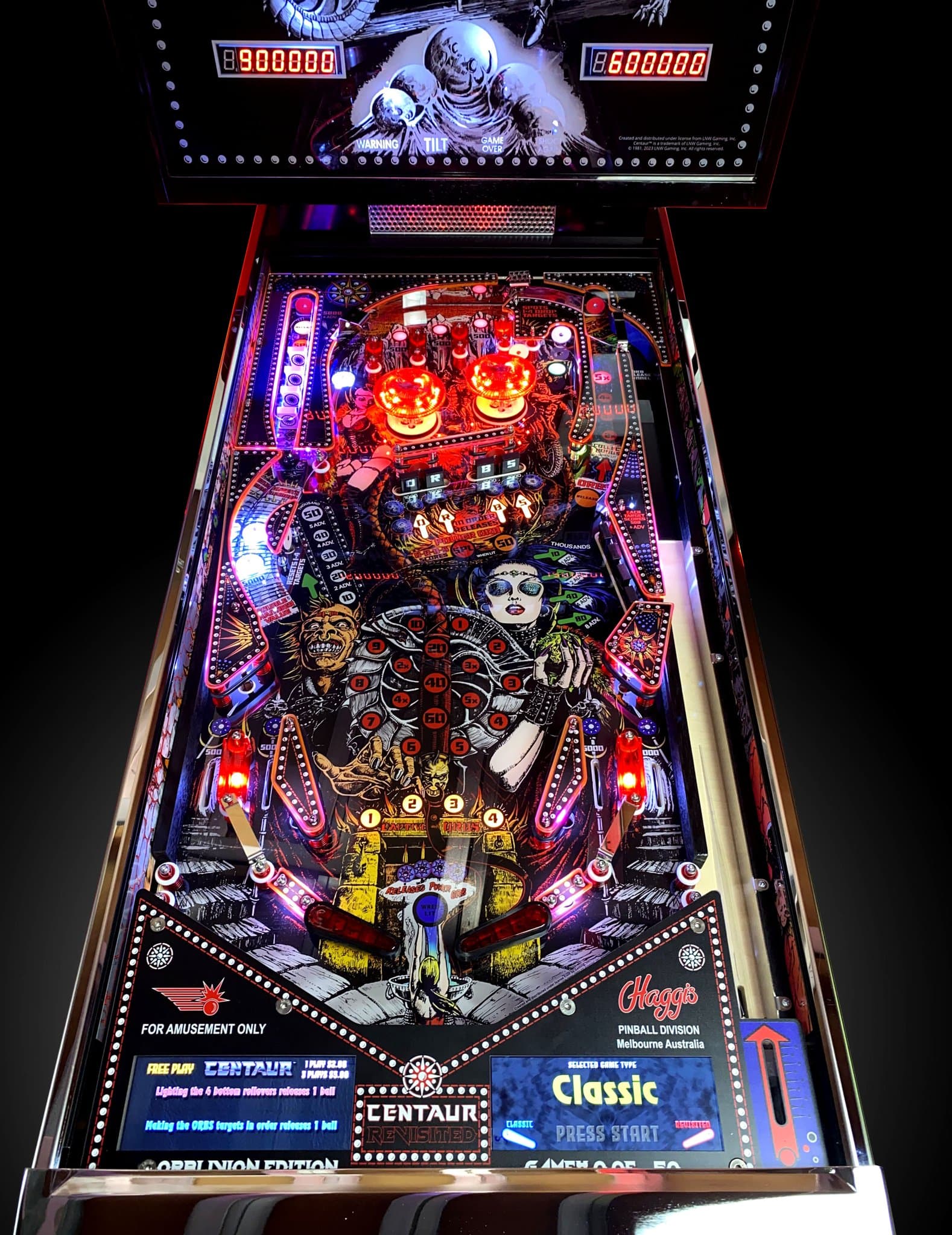 Colorful Halloween-themed pinball machine with glowing jack-o-lanterns and skulls