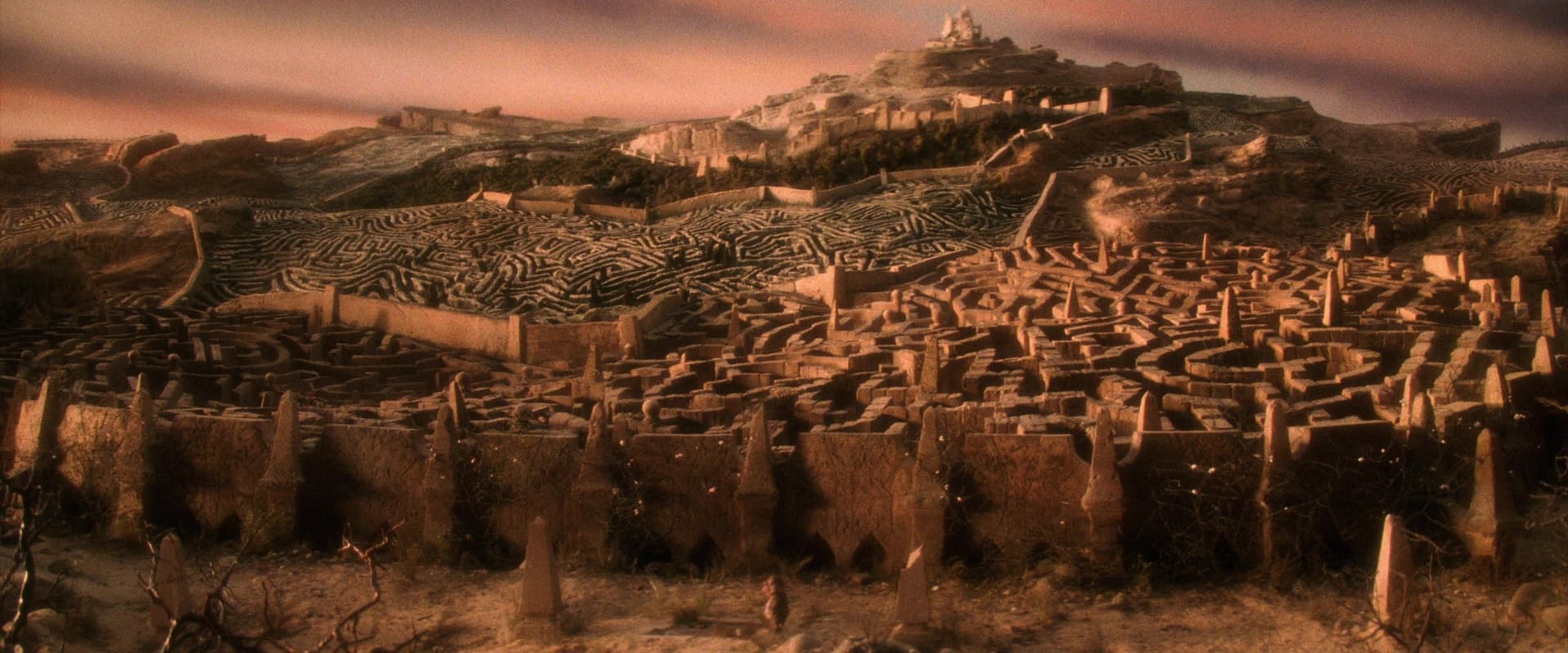 Vast complex labyrinth with intricate stone walls stretching across desert landscape