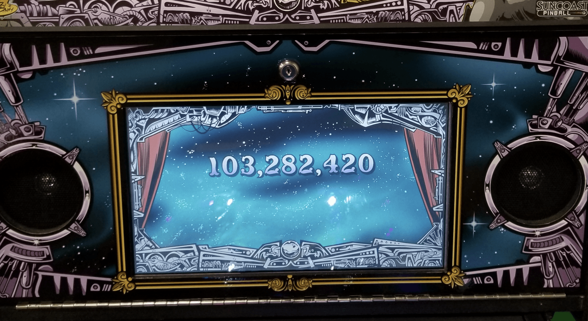 Pinball machine display showing large score of 103,282,420 in starry background
