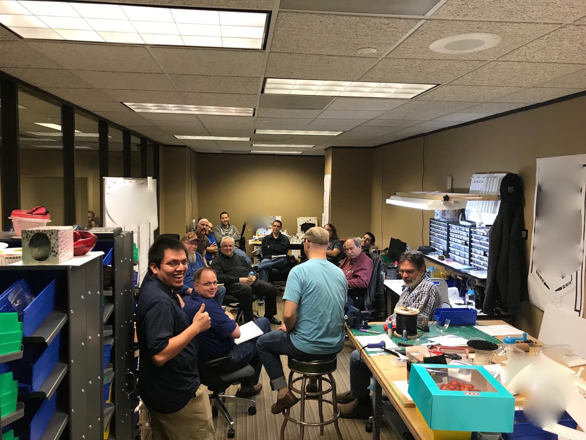 Workshop meeting with employees gathered in a technical workspace