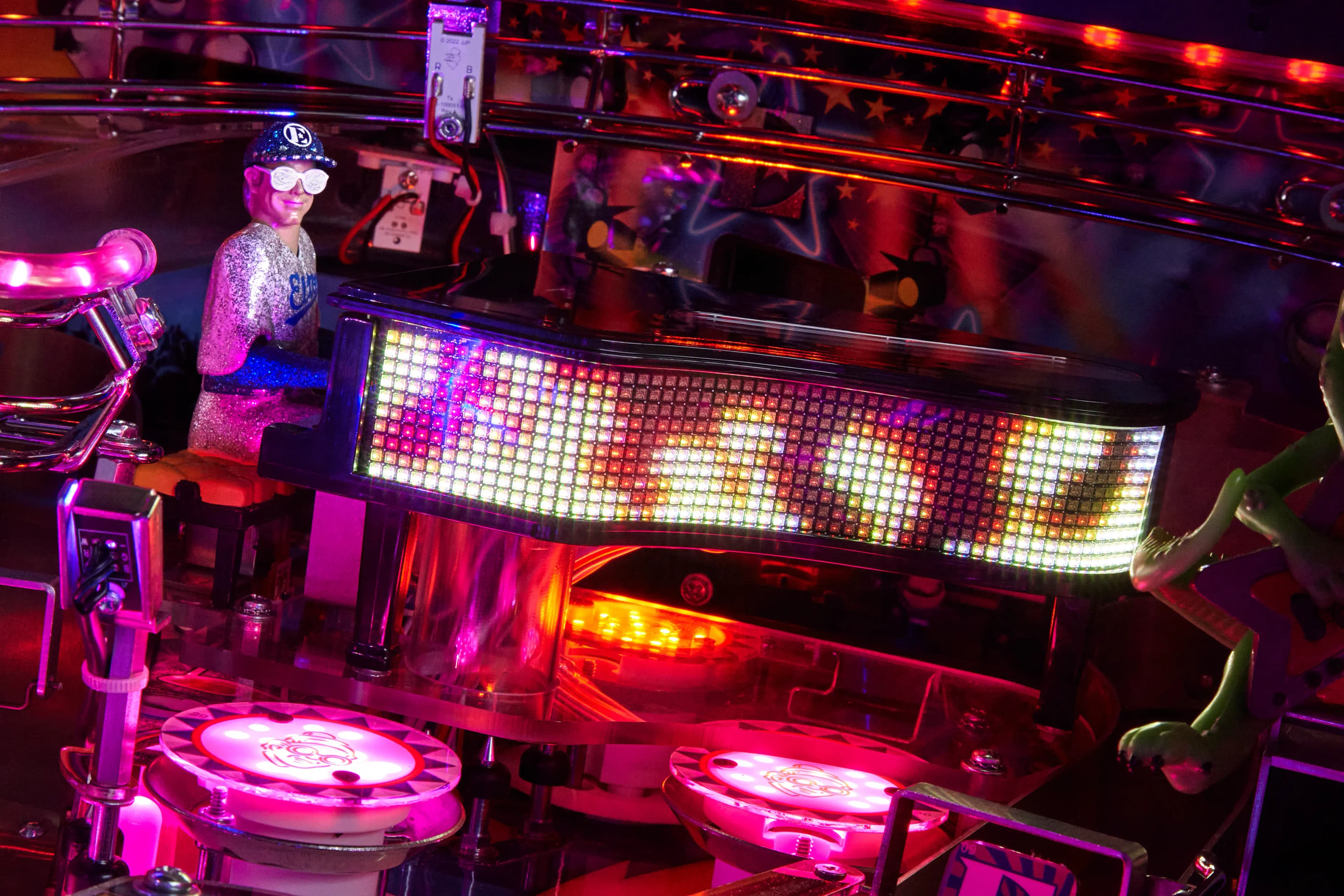 Colorful pinball machine with glowing lights and electronic display board