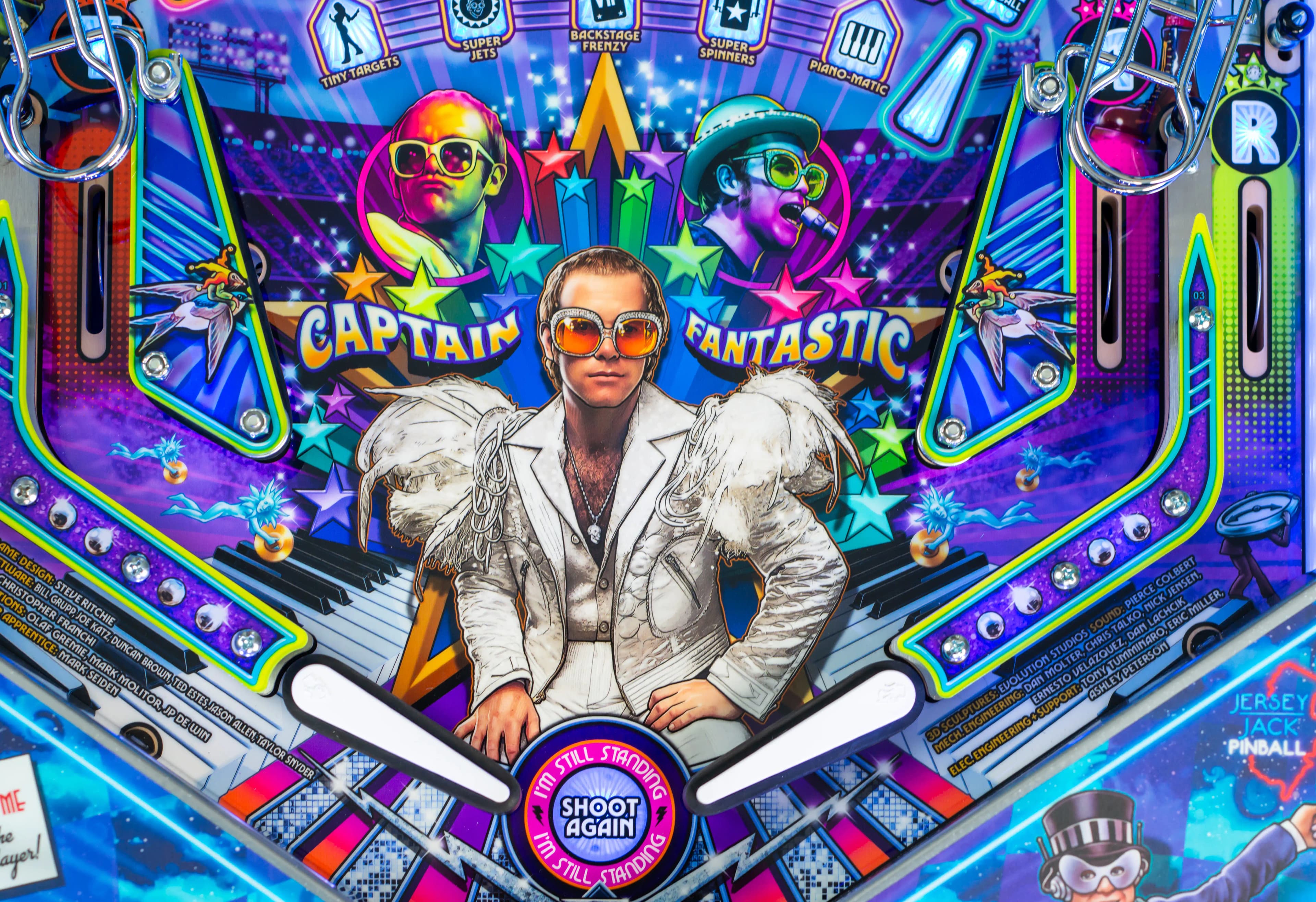 Colorful pinball machine backglass featuring a flamboyant musician in white