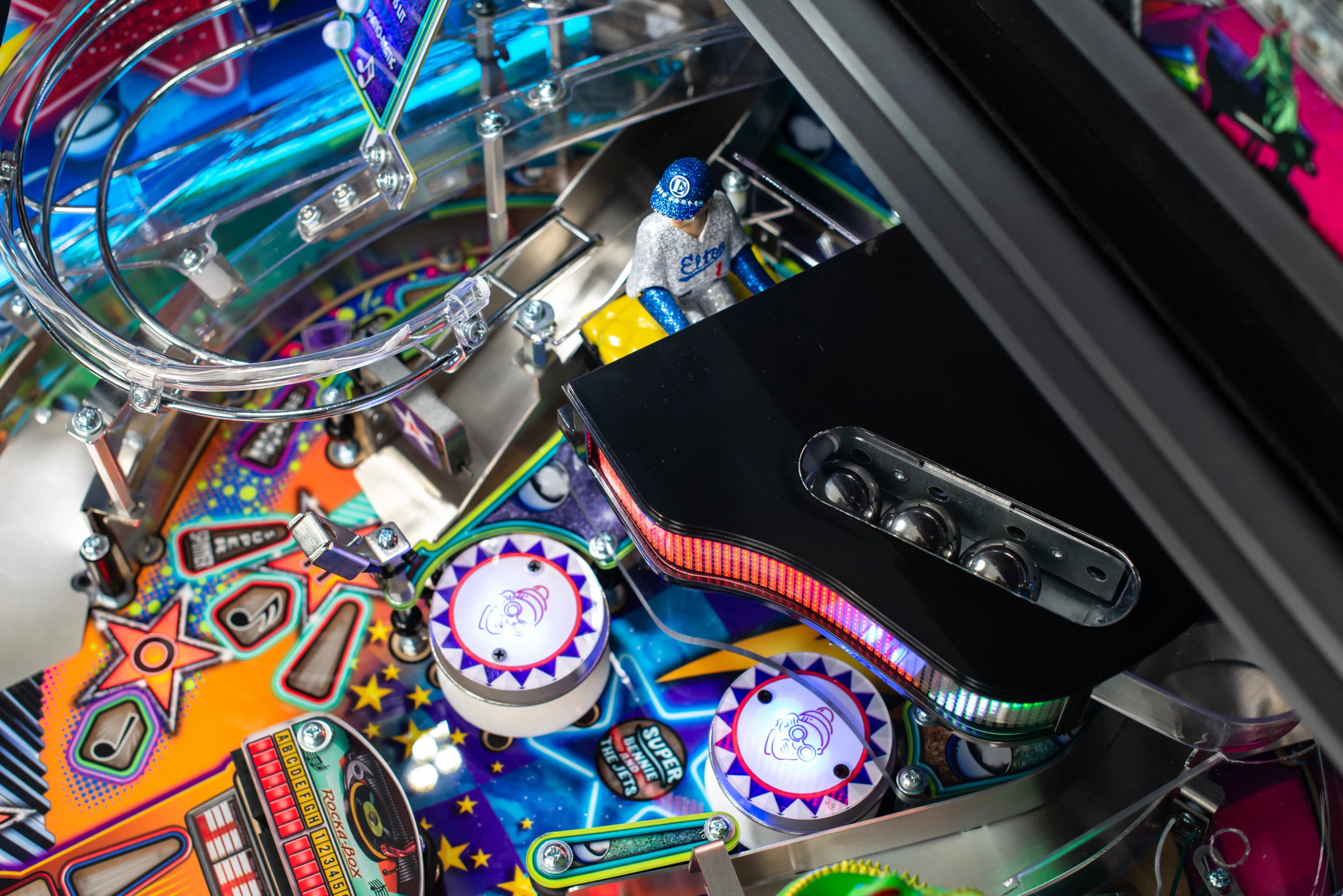 Colorful pinball machine with vibrant playfield, lights, and metallic components