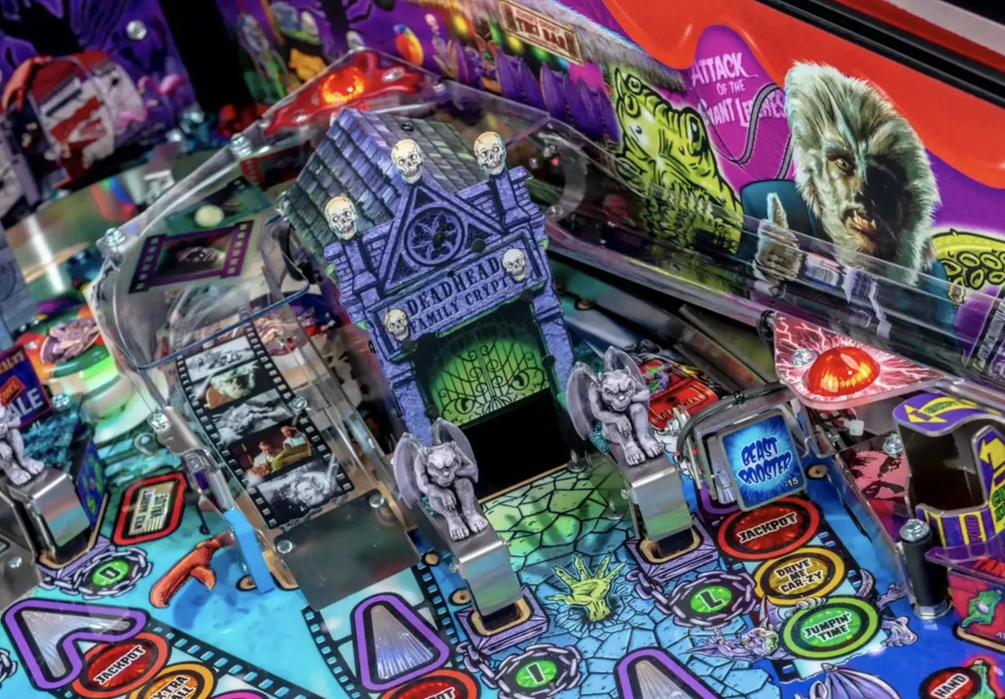 Colorful horror-themed pinball machine with skulls, gargoyles, and monsters