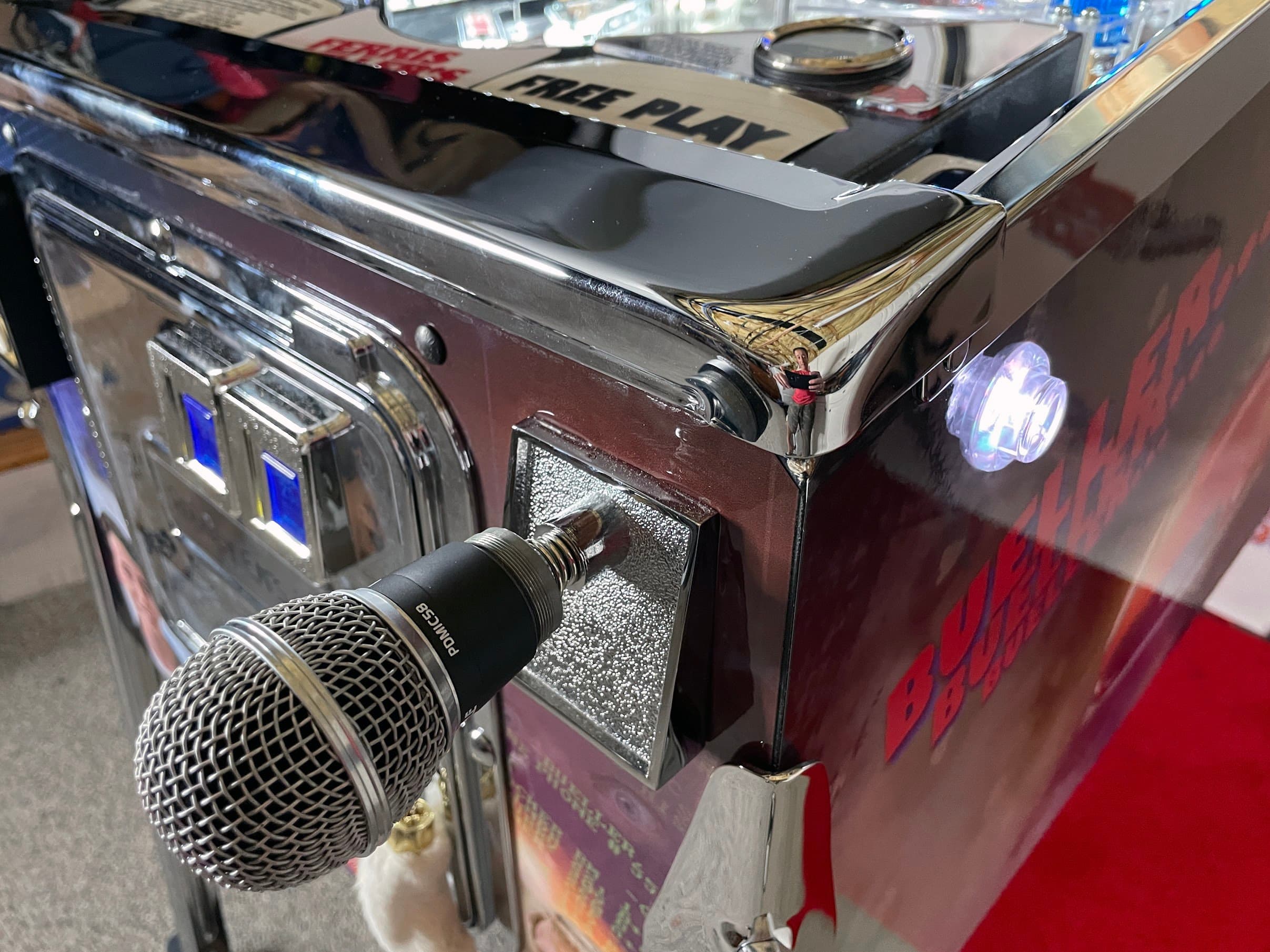 Vintage microphone plugged into chrome-edged audio equipment with glowing lights