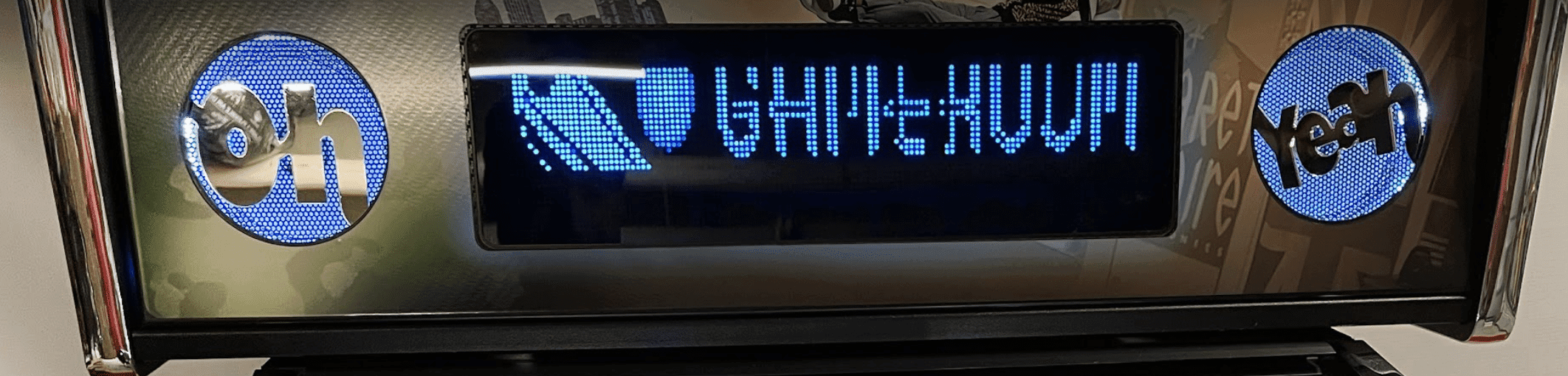 Blue LED display with digital text and circular logos on dark background