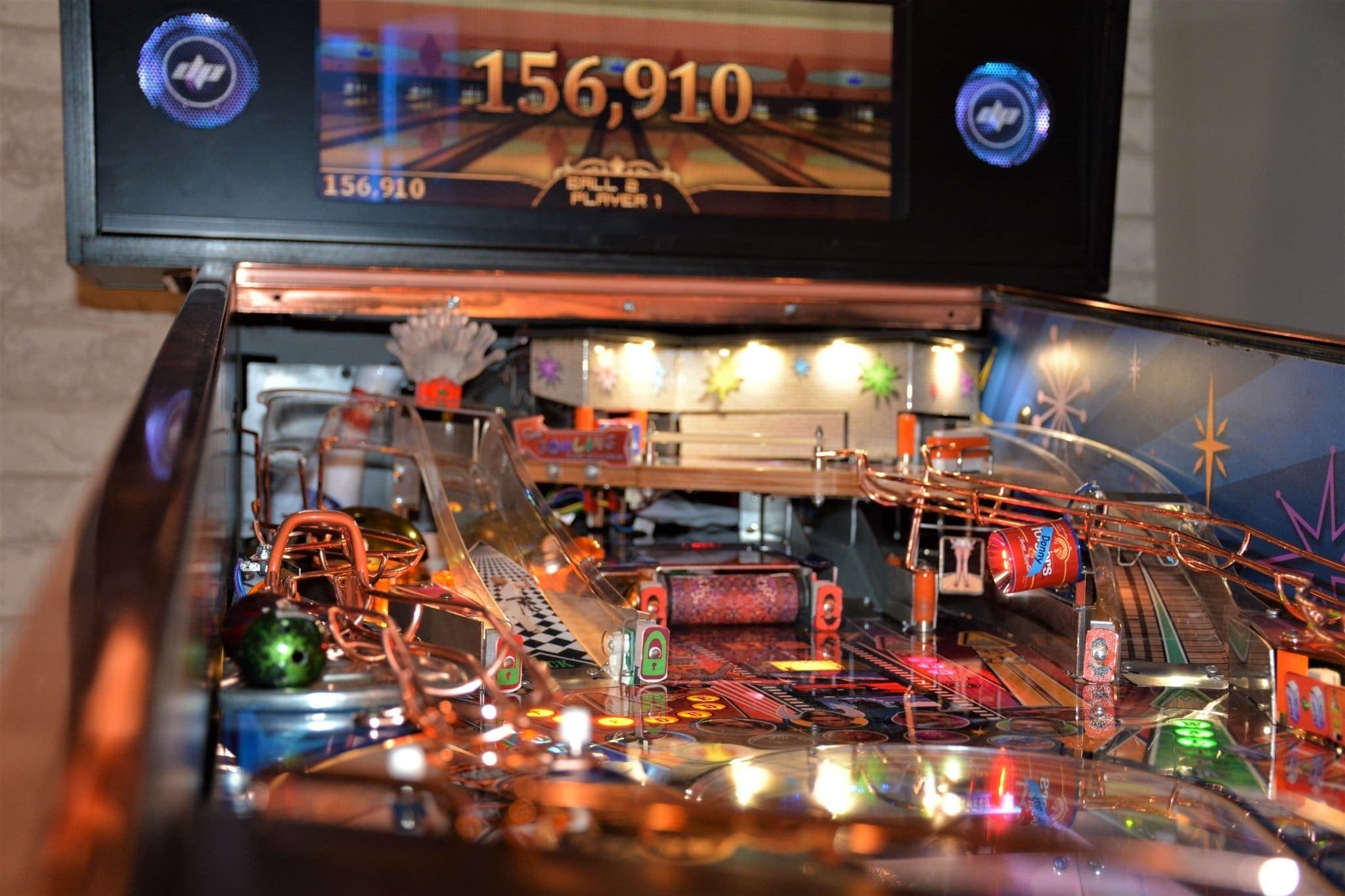 Pinball machine with illuminated playfield and 156,910 score displayed