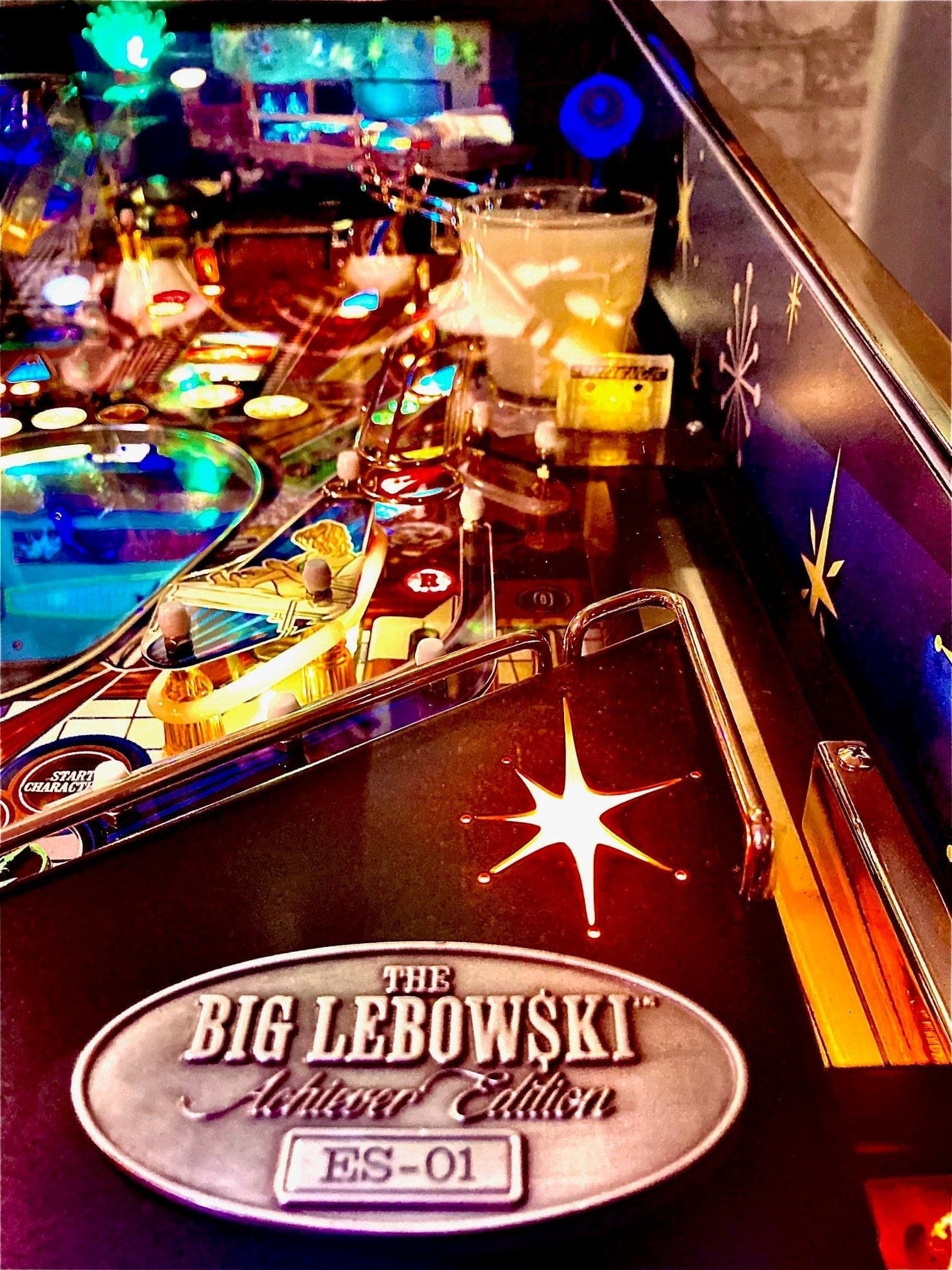 The Big Lebowski pinball machine with colorful lights and drinks