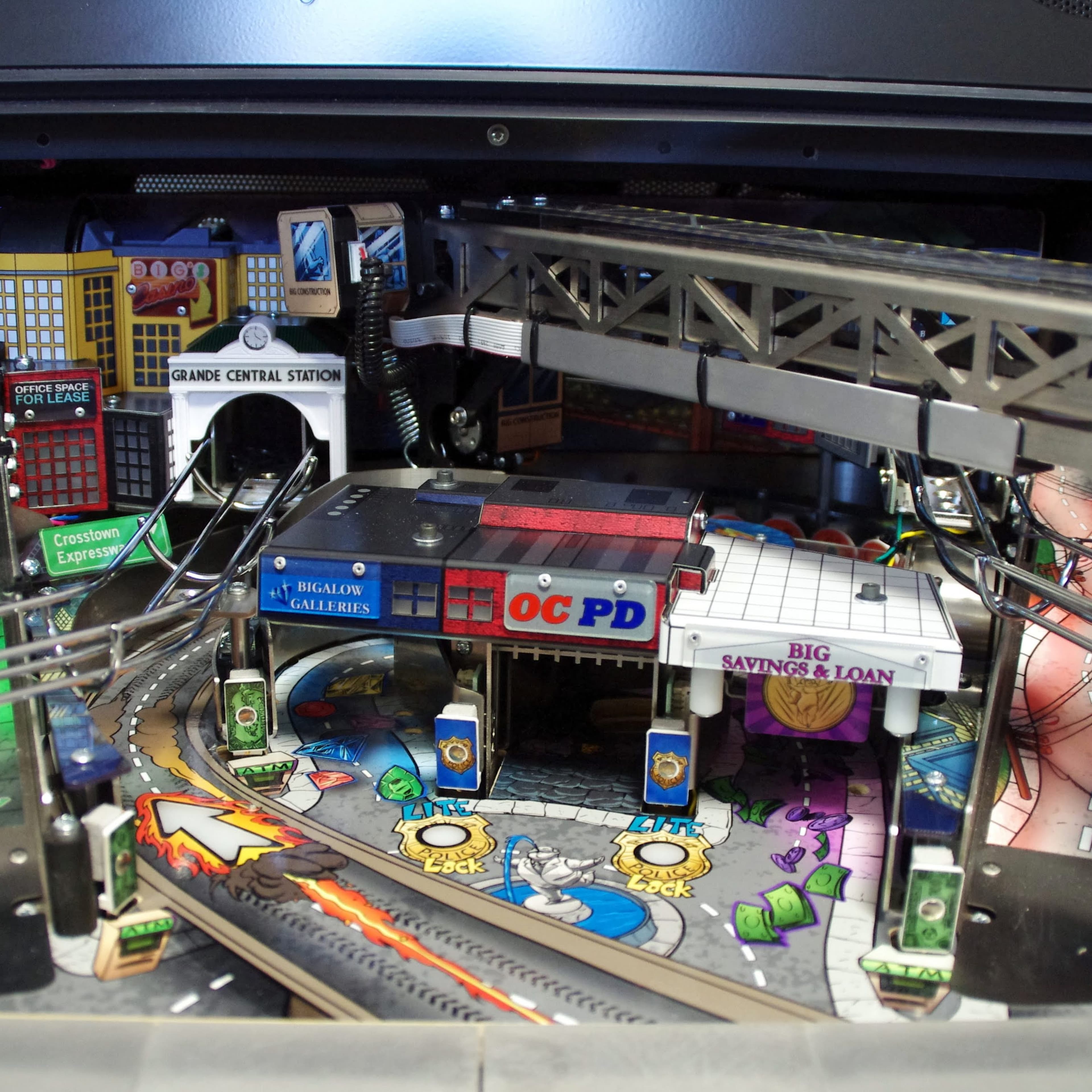 Detailed pinball machine board with city-themed landmarks and police station