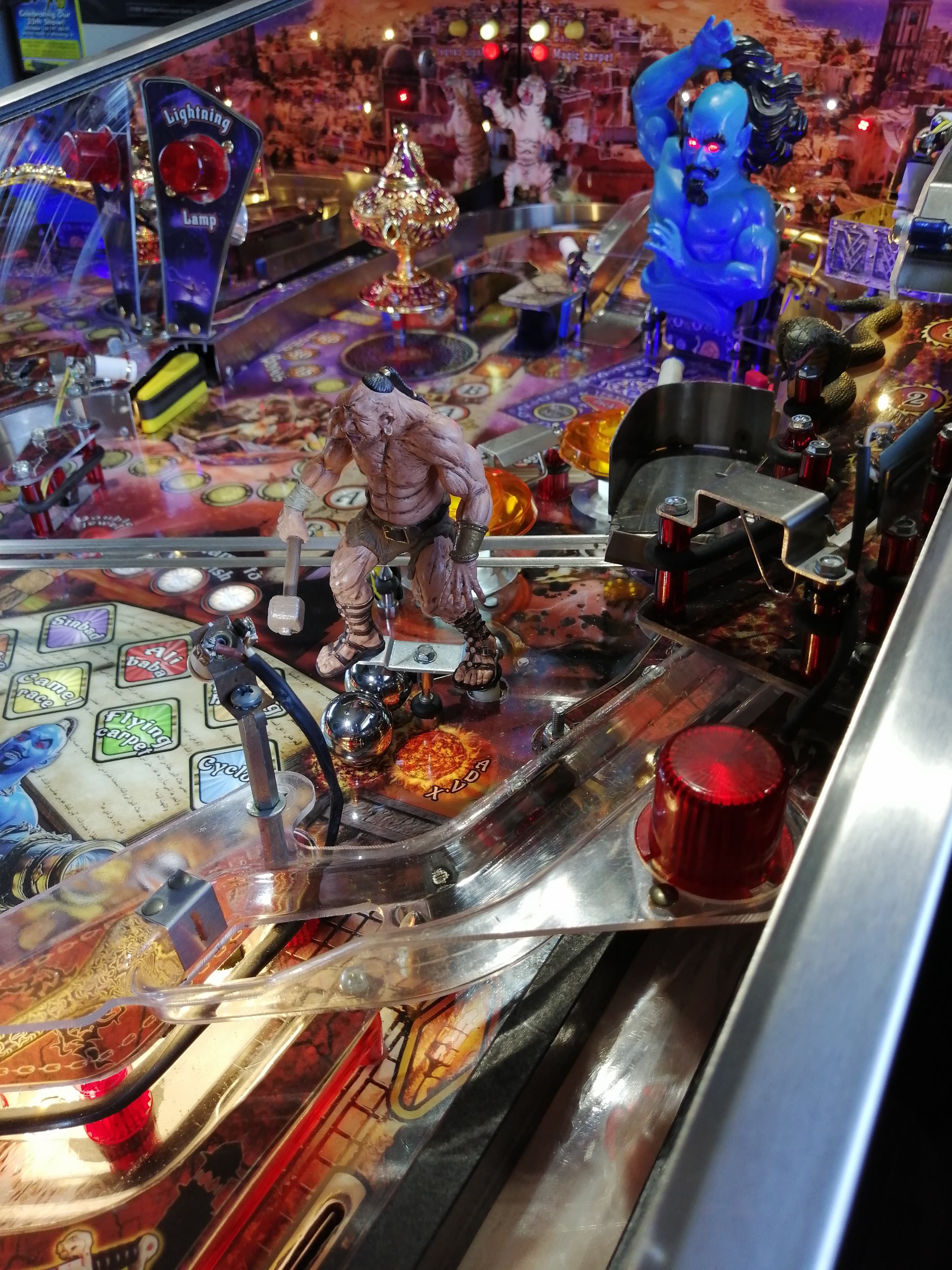 Fantasy pinball machine with colorful creatures and glowing lights