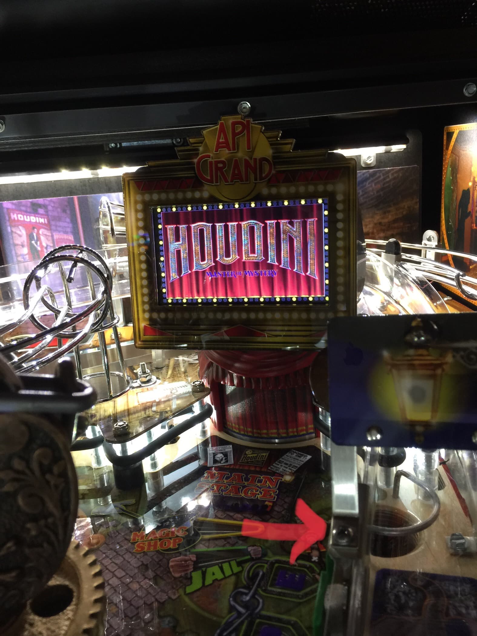Houdini-themed pinball machine with illuminated display and API Grand logo