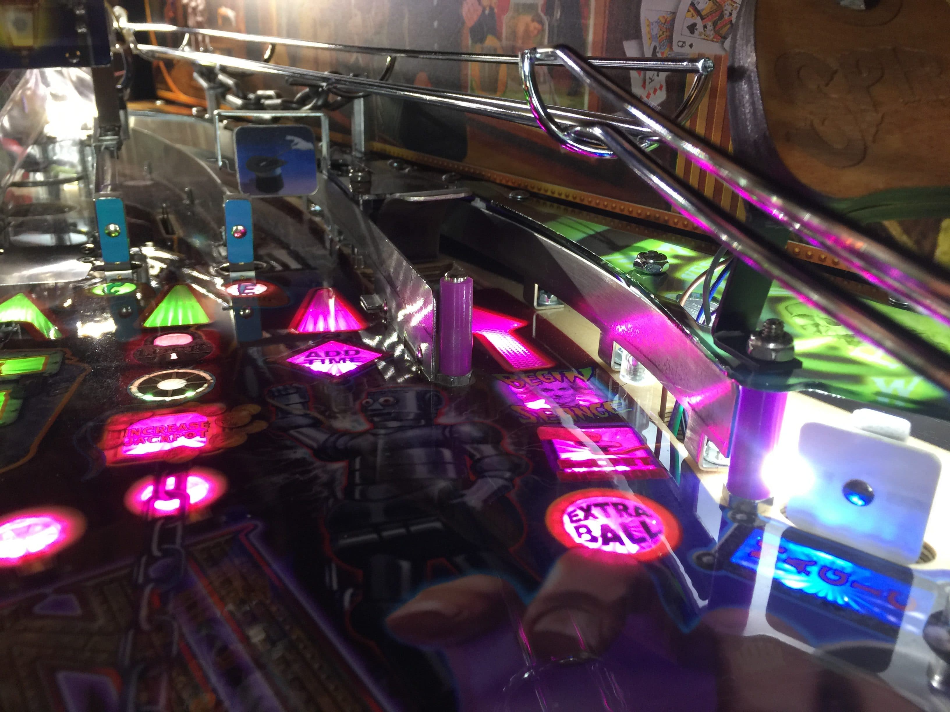 Colorful pinball machine with illuminated buttons and chrome elements