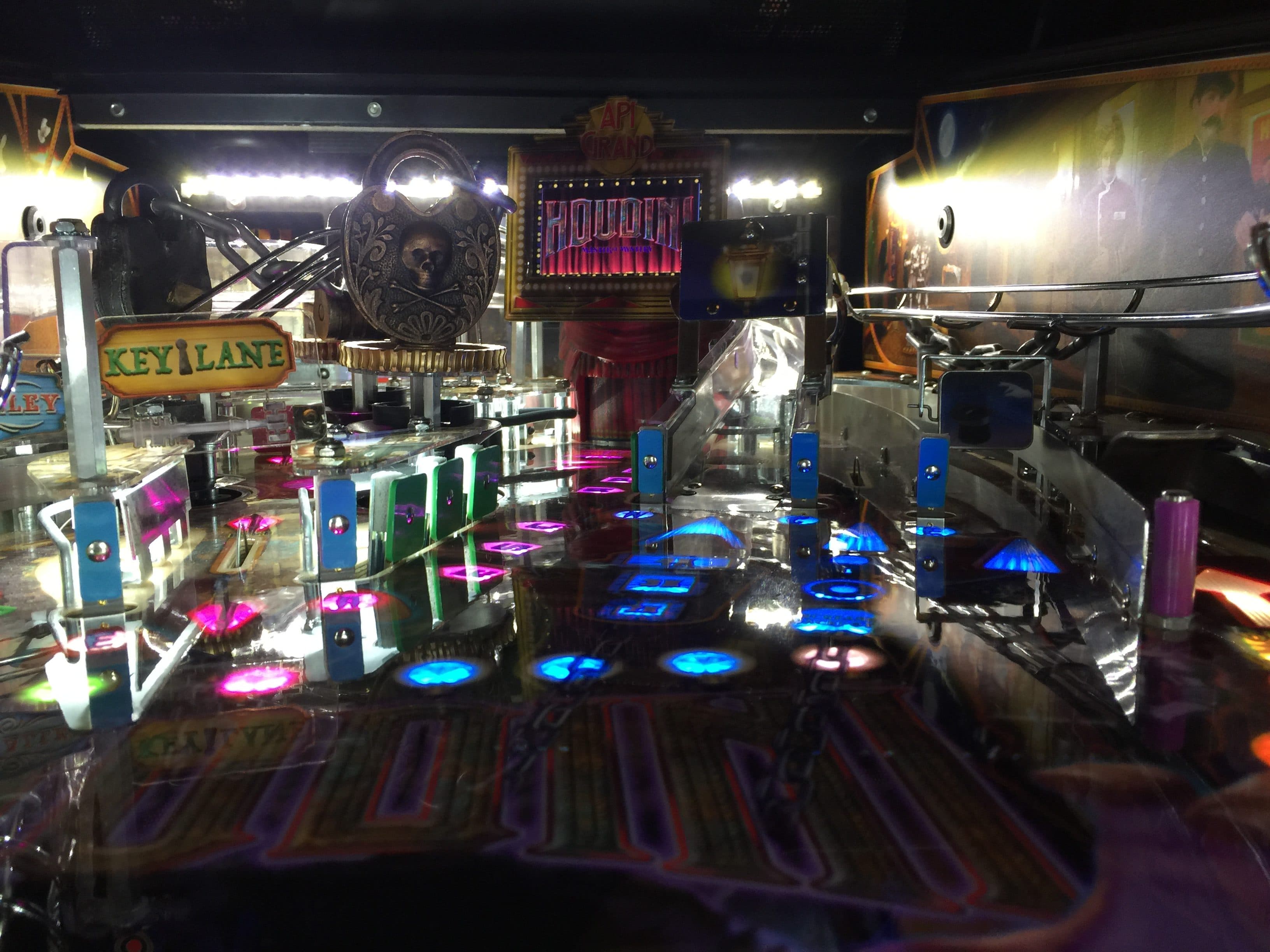 Colorful illuminated pinball machine with Houdini theme and glowing elements