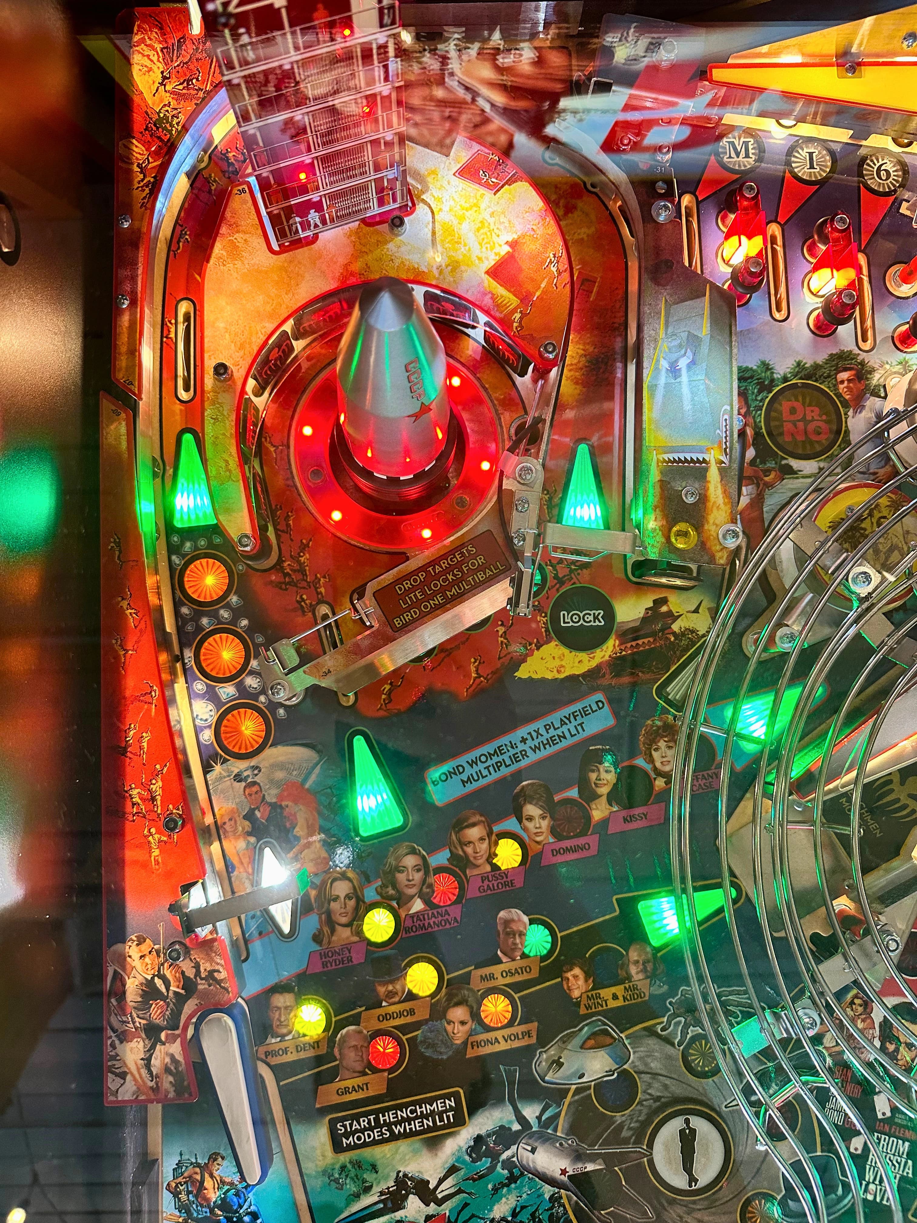 Colorful vintage pinball machine with glowing lights and character illustrations