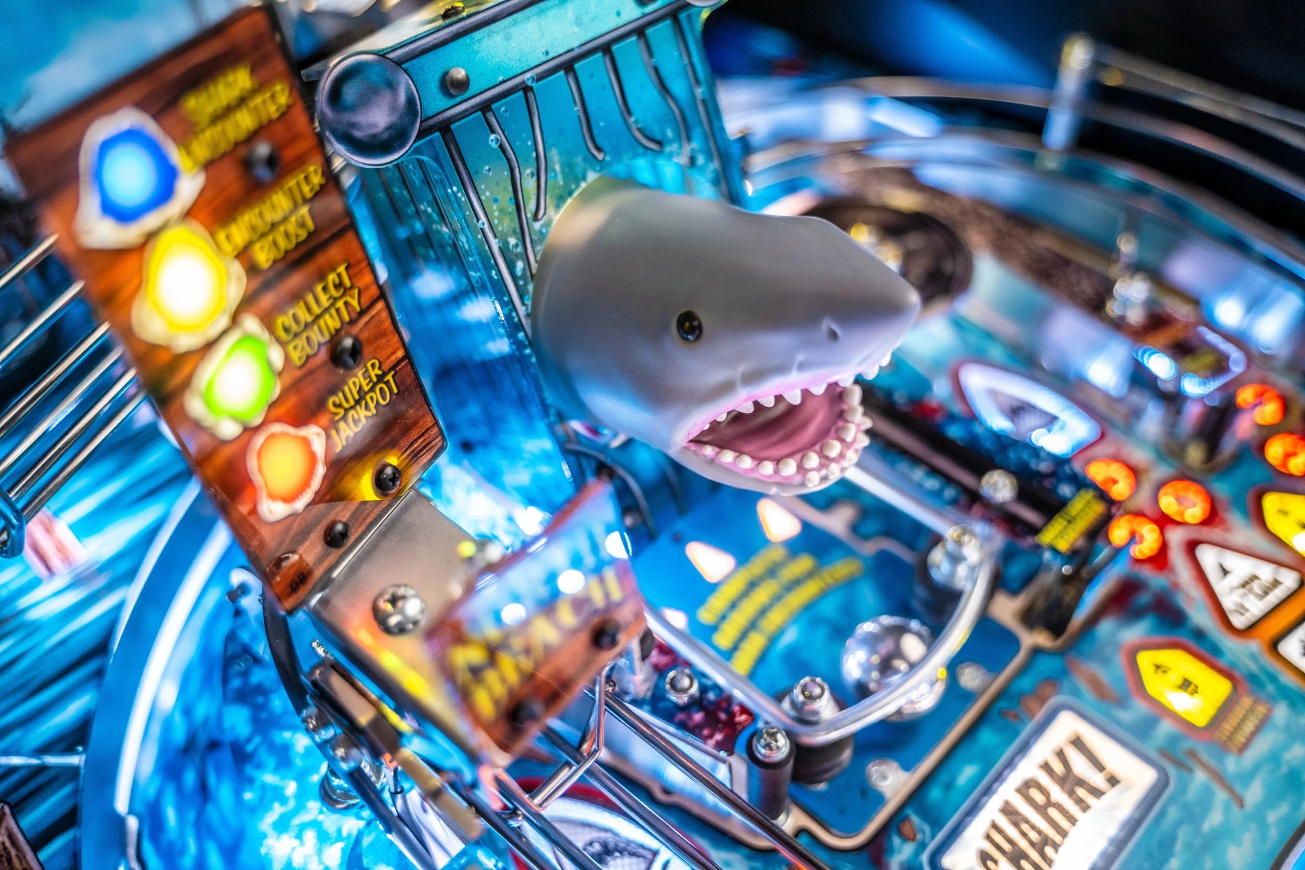 Colorful pinball machine with shark head and glowing buttons