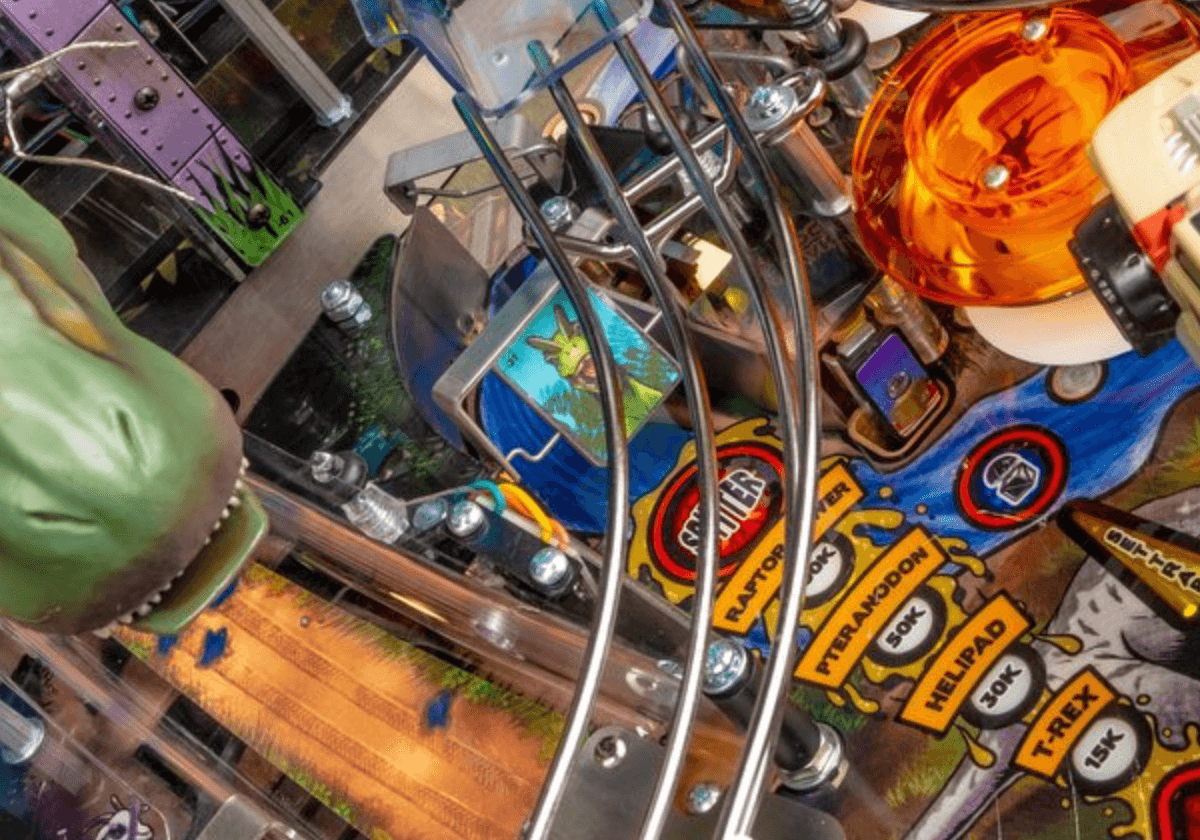 Detailed pinball machine with colorful playfield, metal rails, and game markers