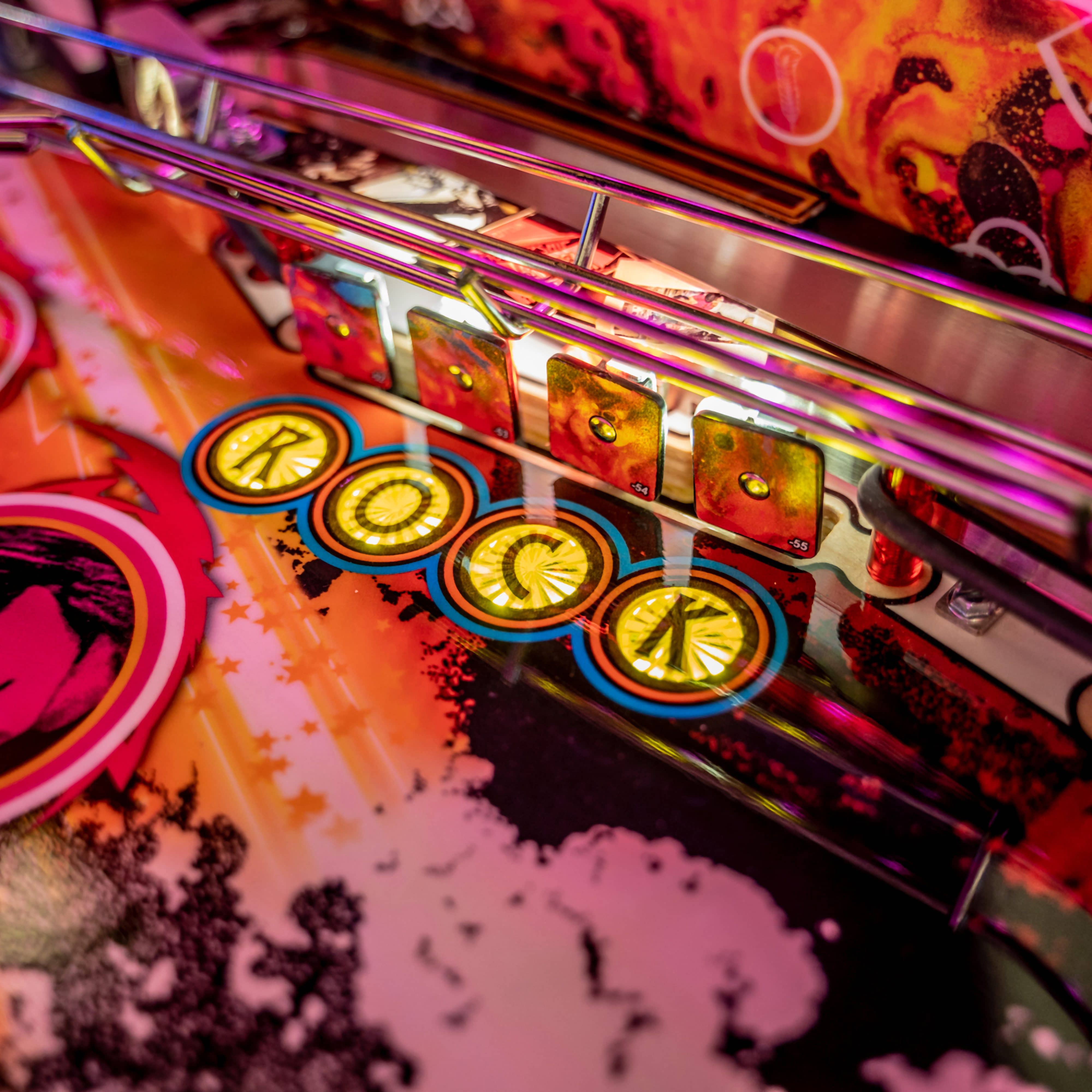 Colorful pinball machine with glowing yellow circular buttons and vibrant background