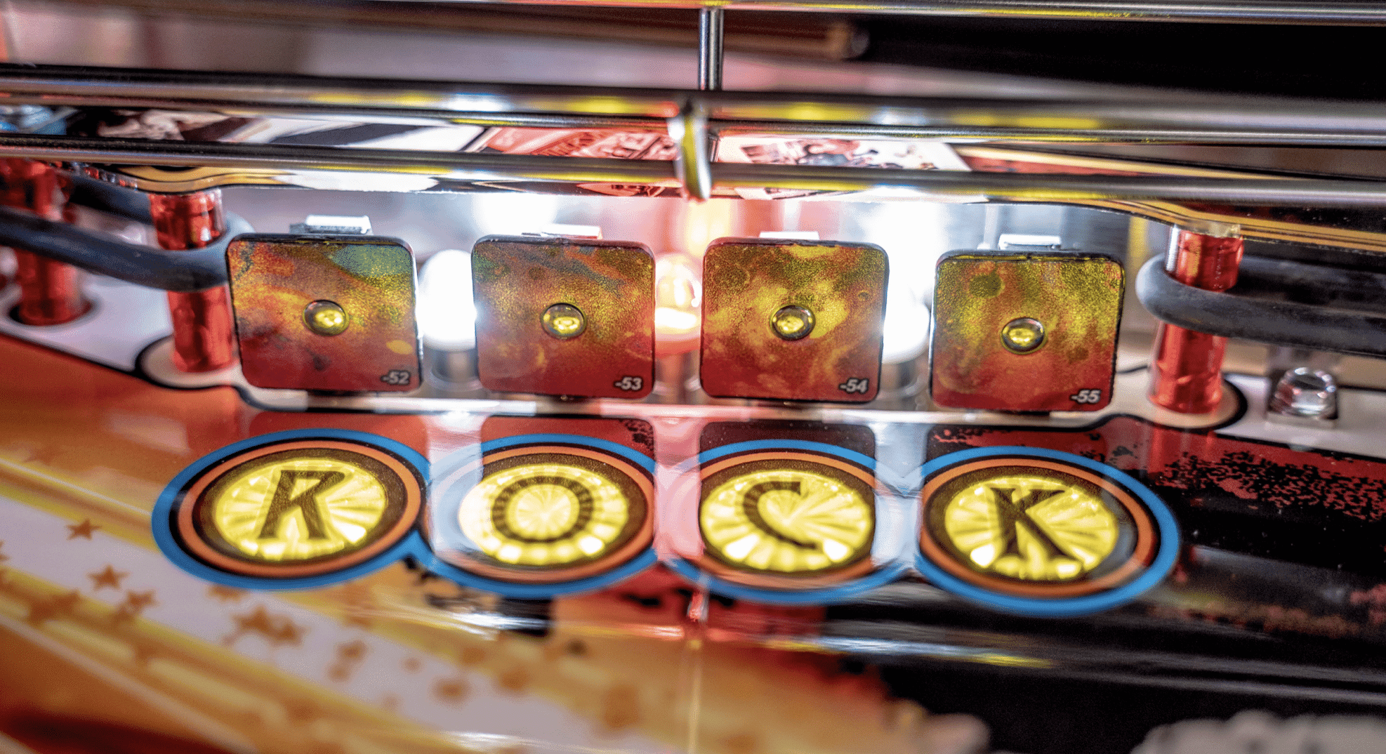 Closeup of pinball machine display with glowing yellow and red numbered panels
