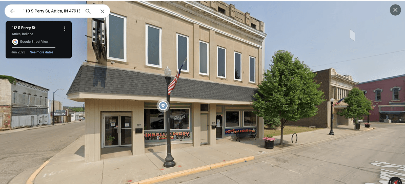 Small-town street corner with Kimball's Perry store and American flag
