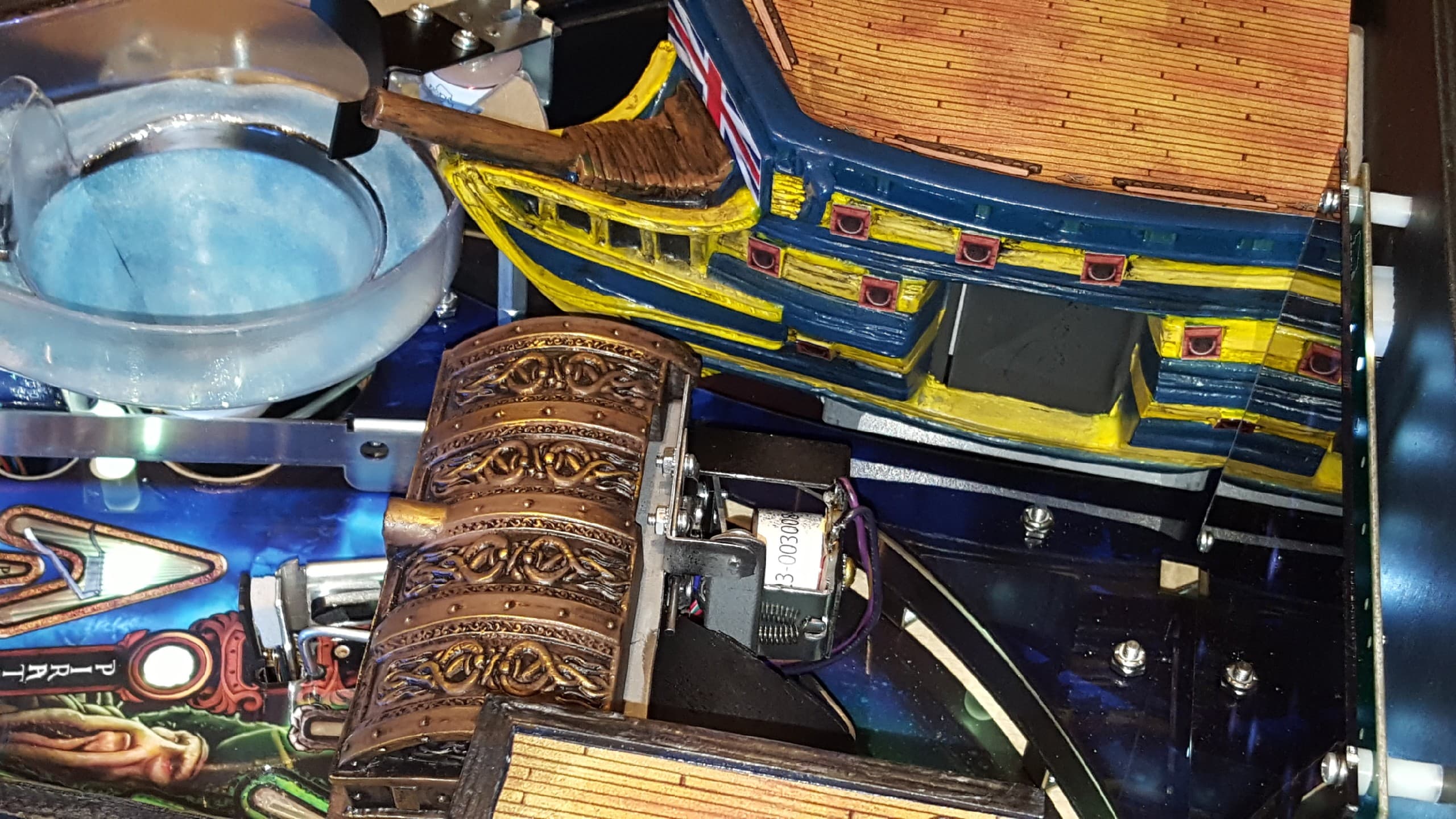 Intricate pinball machine interior with ornate ship and mechanical components