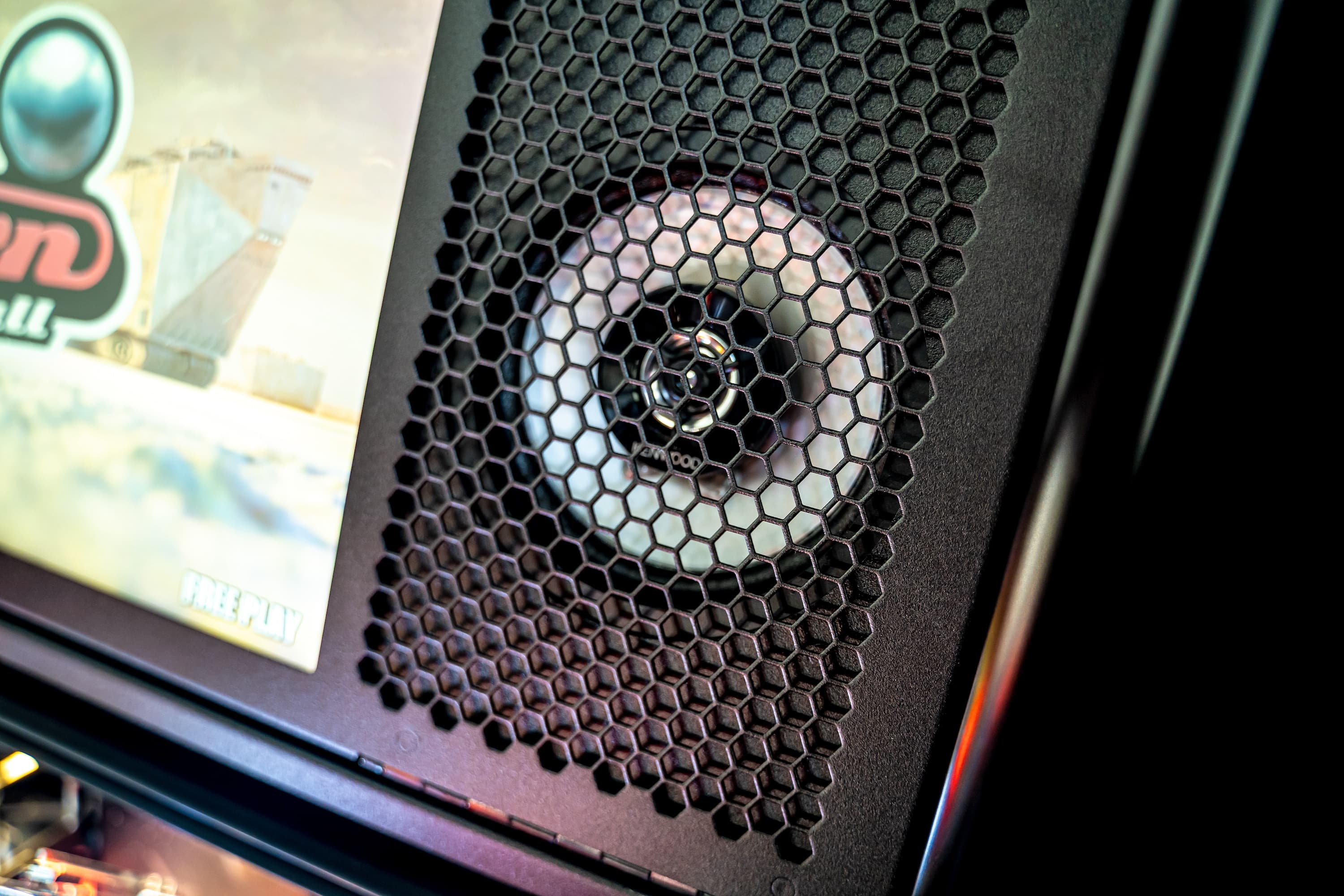 Computer case with hexagonal mesh ventilation and blurred screen background