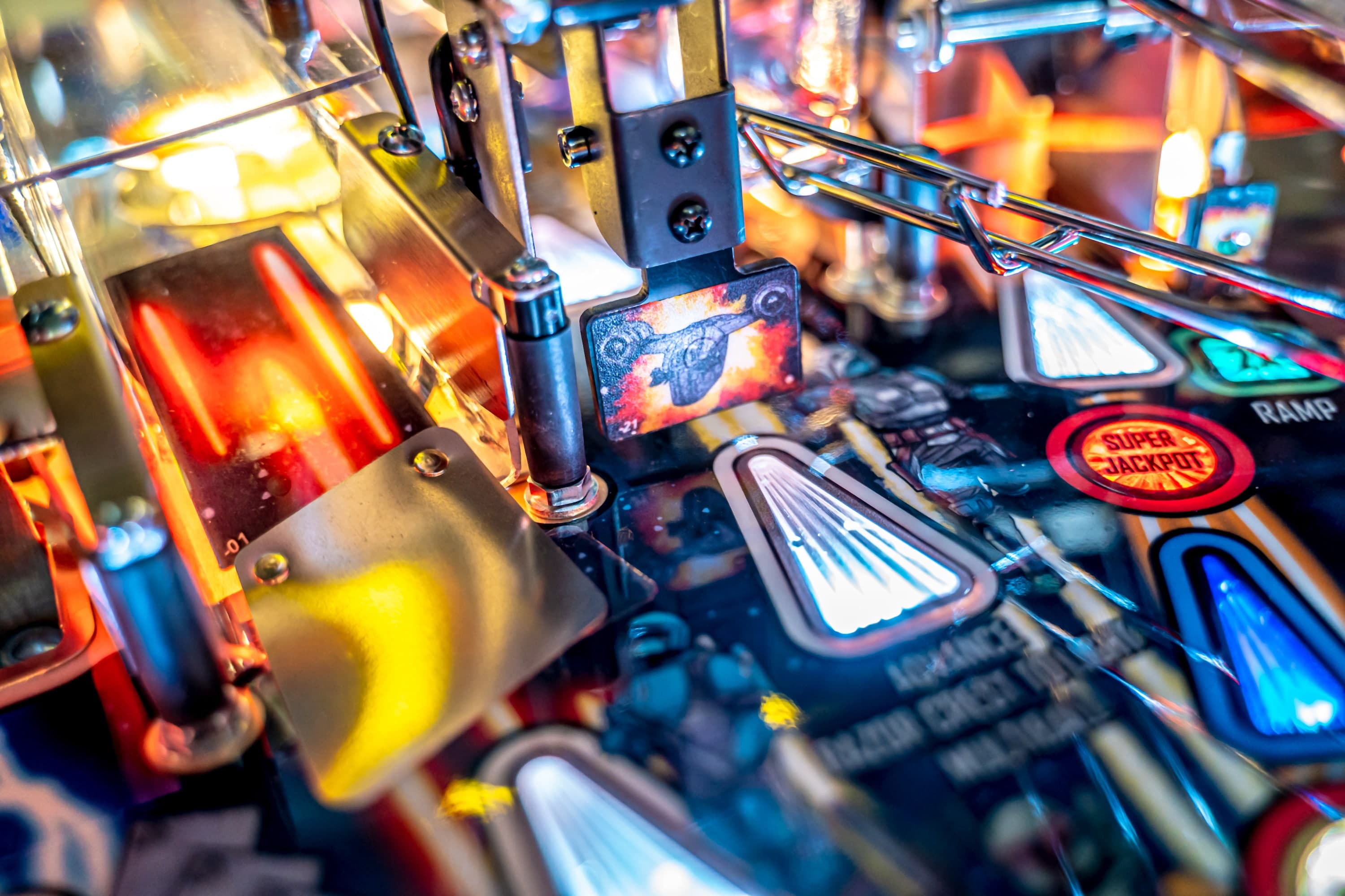 Close-up of colorful pinball machine with metallic parts and glowing lights