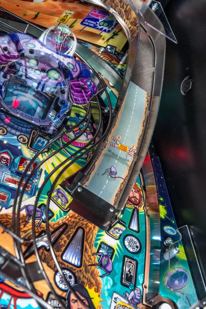 Colorful pinball machine with intricate sci-fi themed playfield and metallic elements