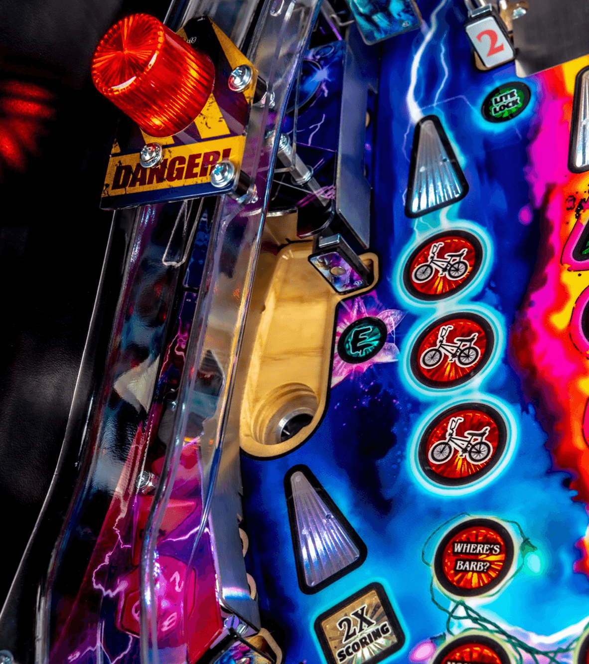 Colorful pinball machine detail with danger sign, warning light, and BMX icons