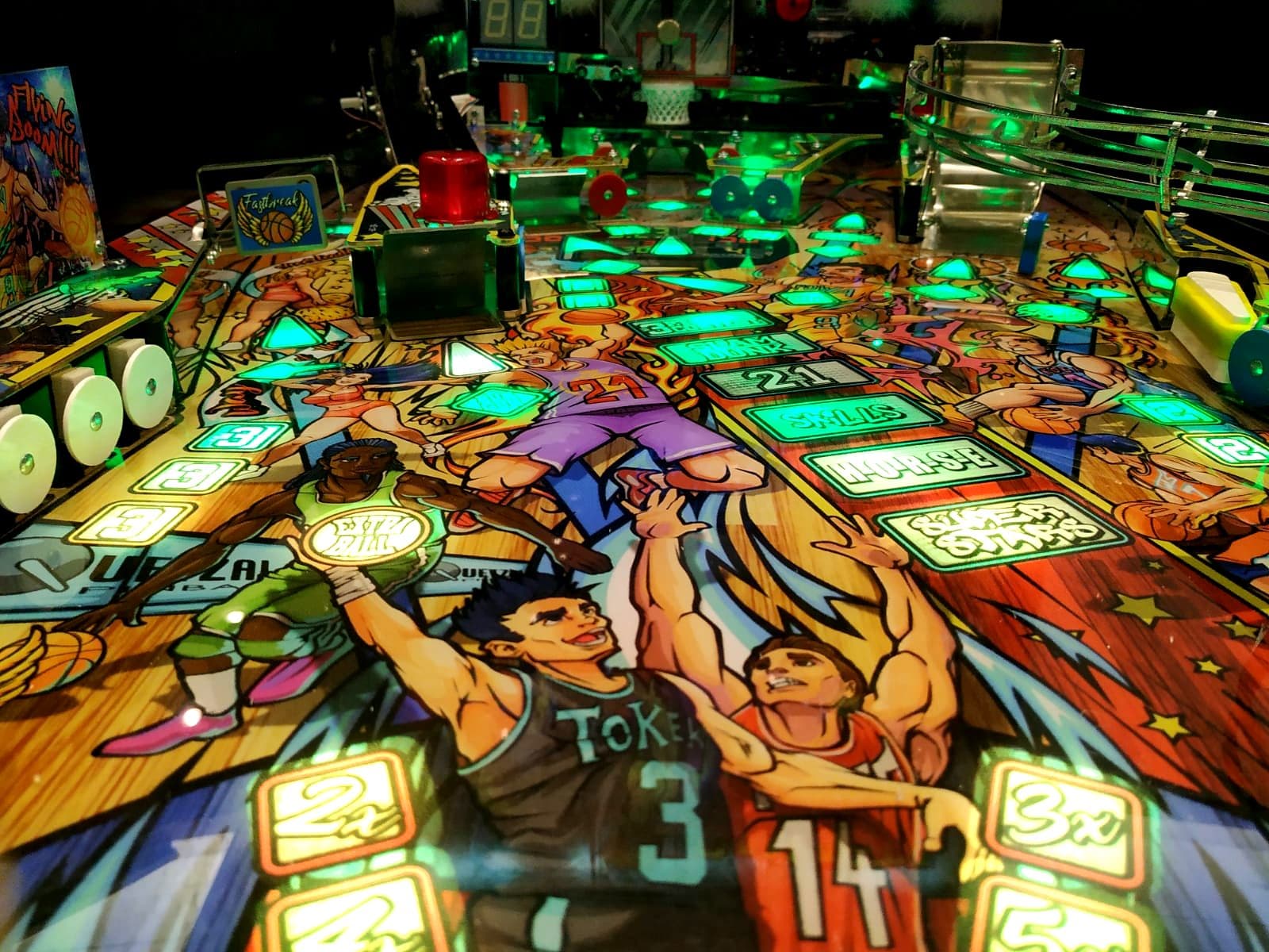 Colorful basketball pinball machine with glowing green and blue lights