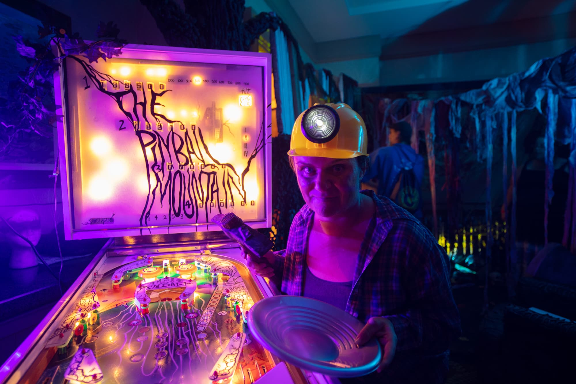 Pinball machine with urban mining theme, player wearing hard hat